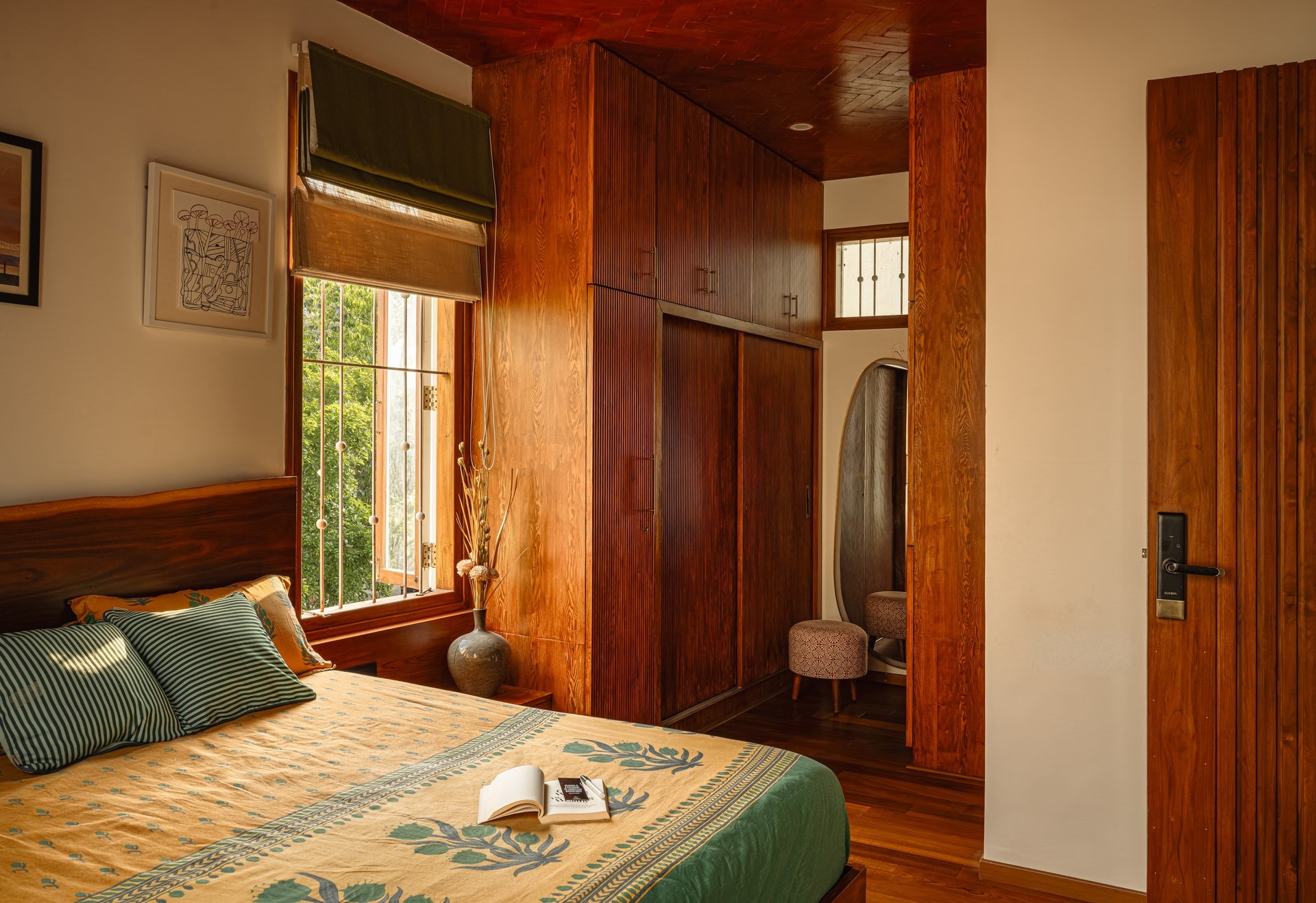 The second bedroom, with a full-height fluted hardwood wardrobe wall concealing the dressing zone