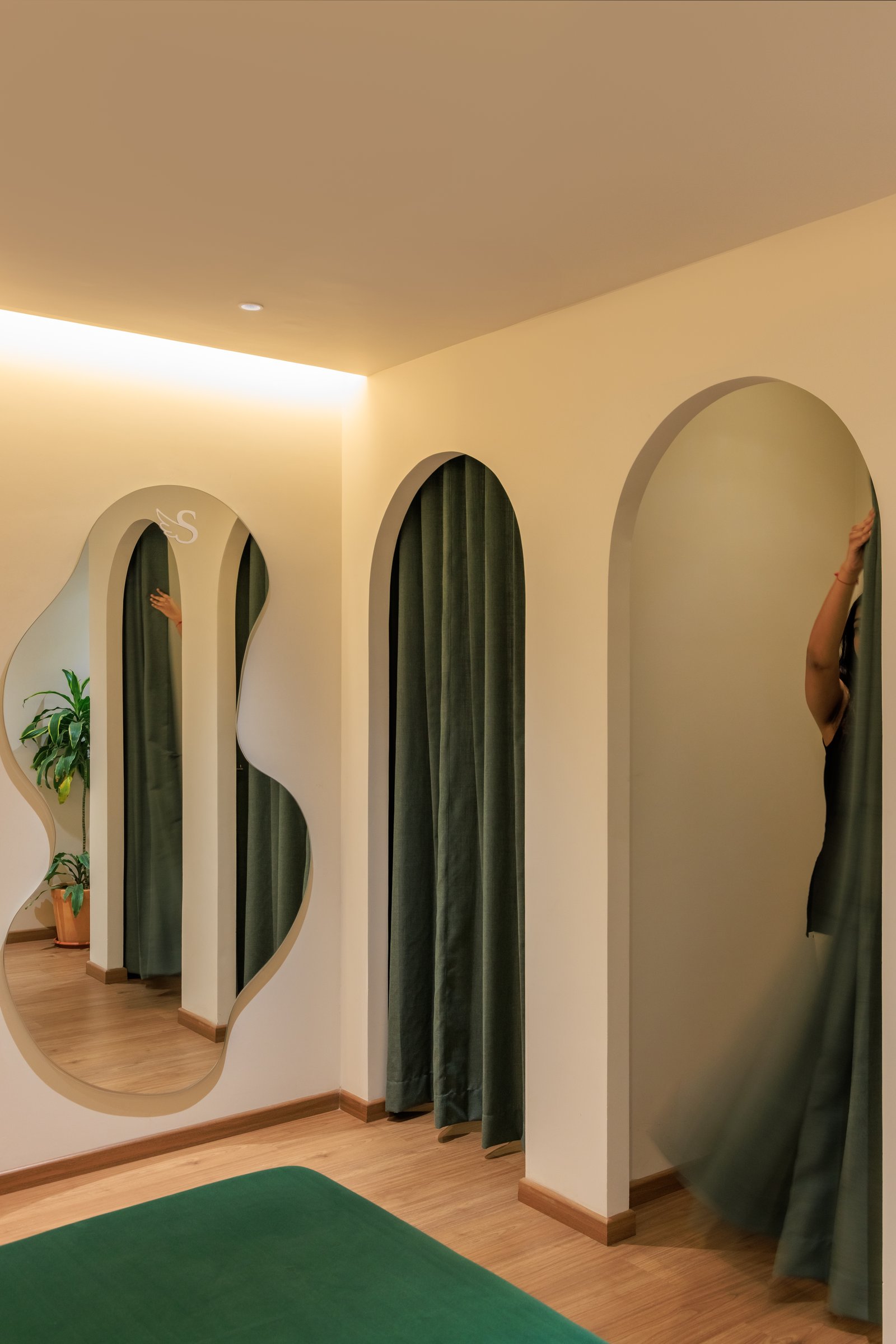 The changing area: arched curtained recesses paired with a freeform mirror