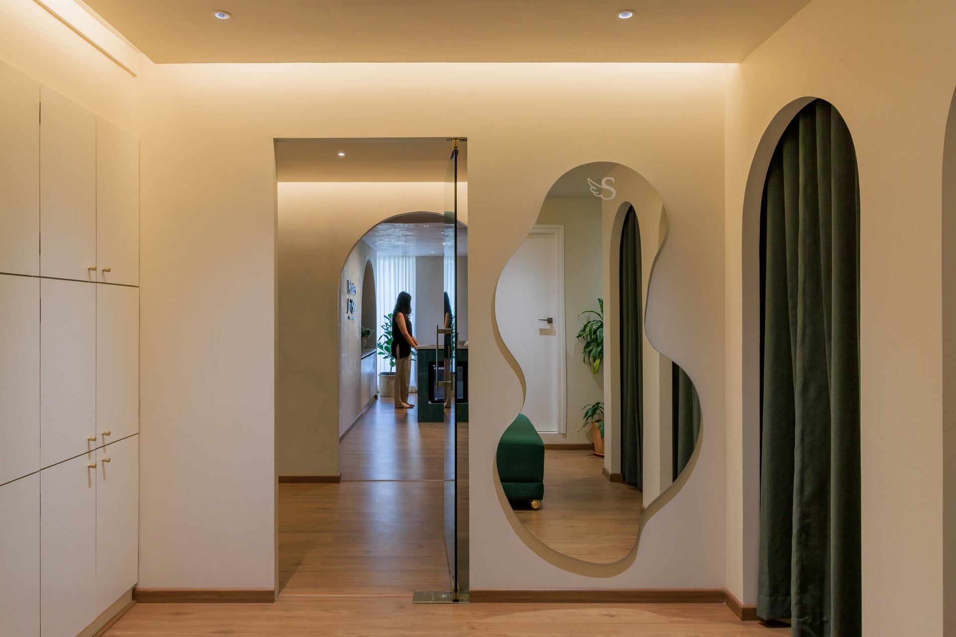 A freeform mirror and arched openings introduce the studio's softer geometry