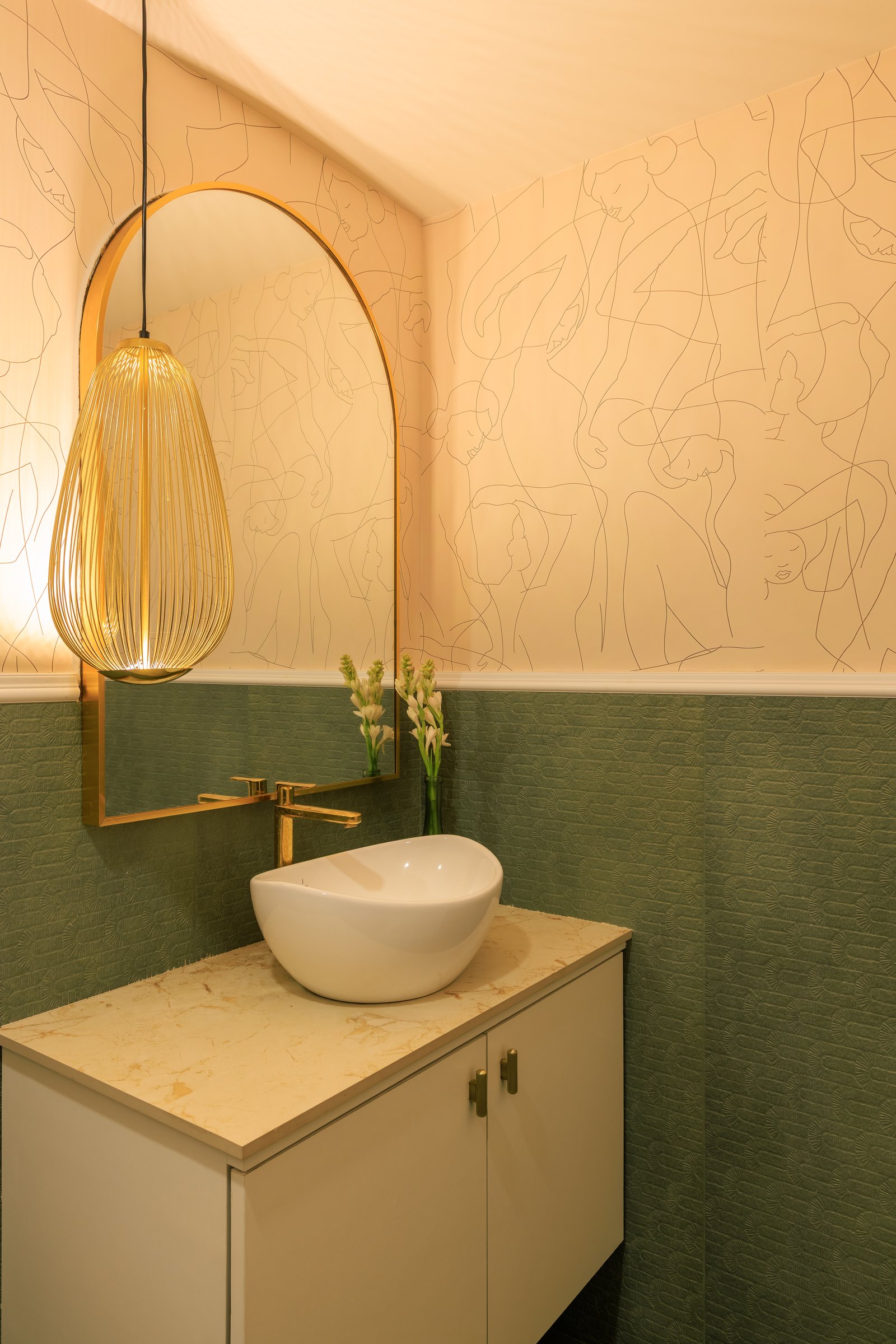 The powder room, where a hand-drawn figural motif meets a green-tiled dado