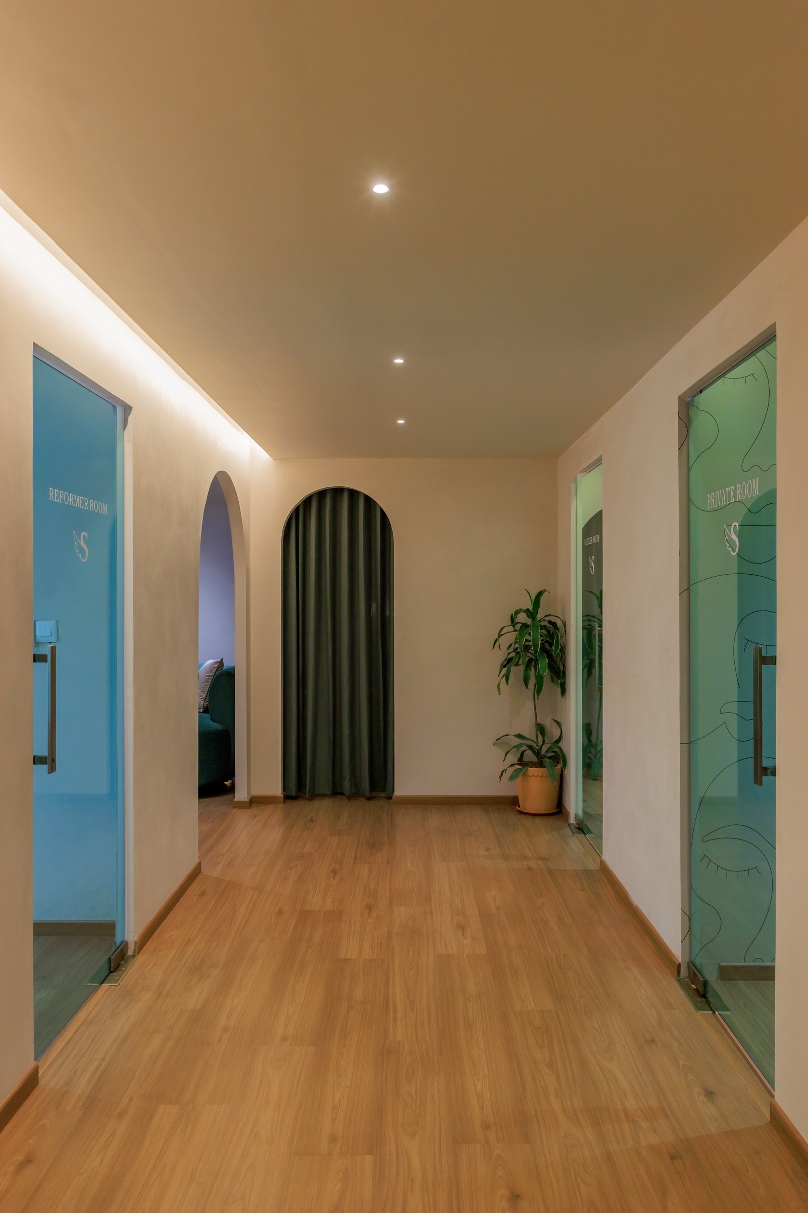 The central corridor: arched openings and etched glass doors organise the plan