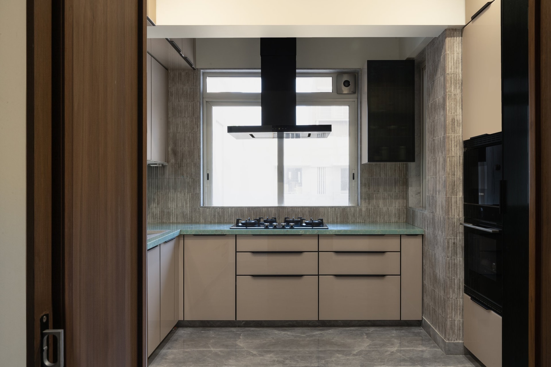 The kitchen's deep green stone counter introduces a colour the rest of the home has carefully withheld