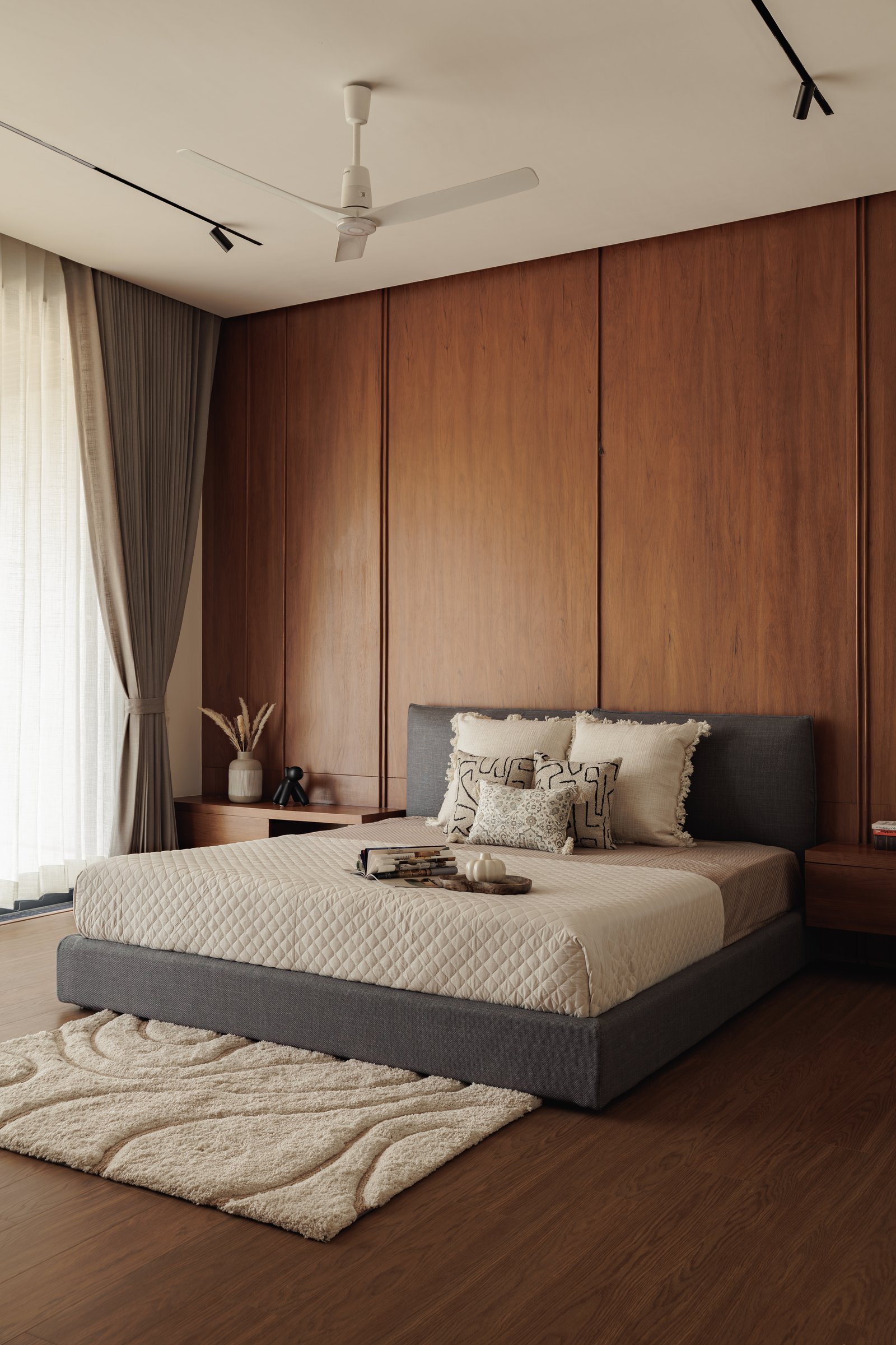 A second view of the master bedroom, the wood wall continuing uninterrupted as the room’s primary architectural gesture
