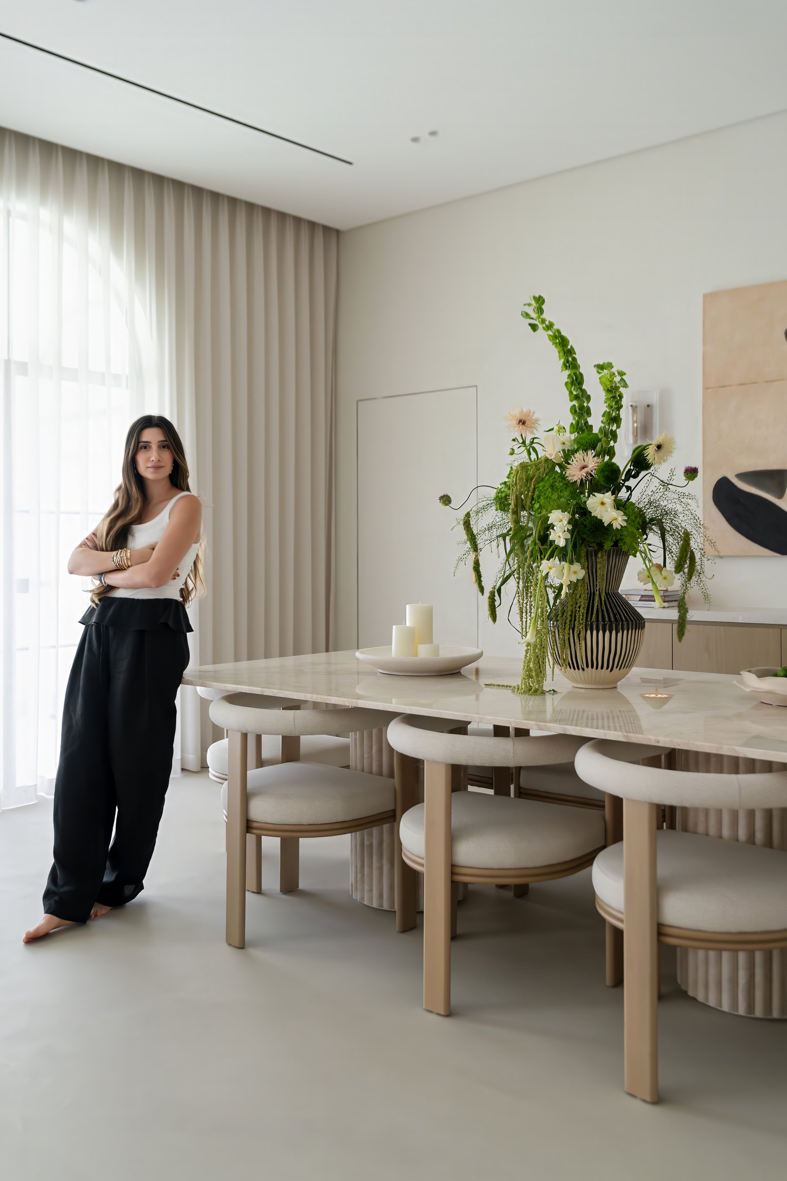 Jessica Khouzami of AHI Interiors at the custom travertine dining table