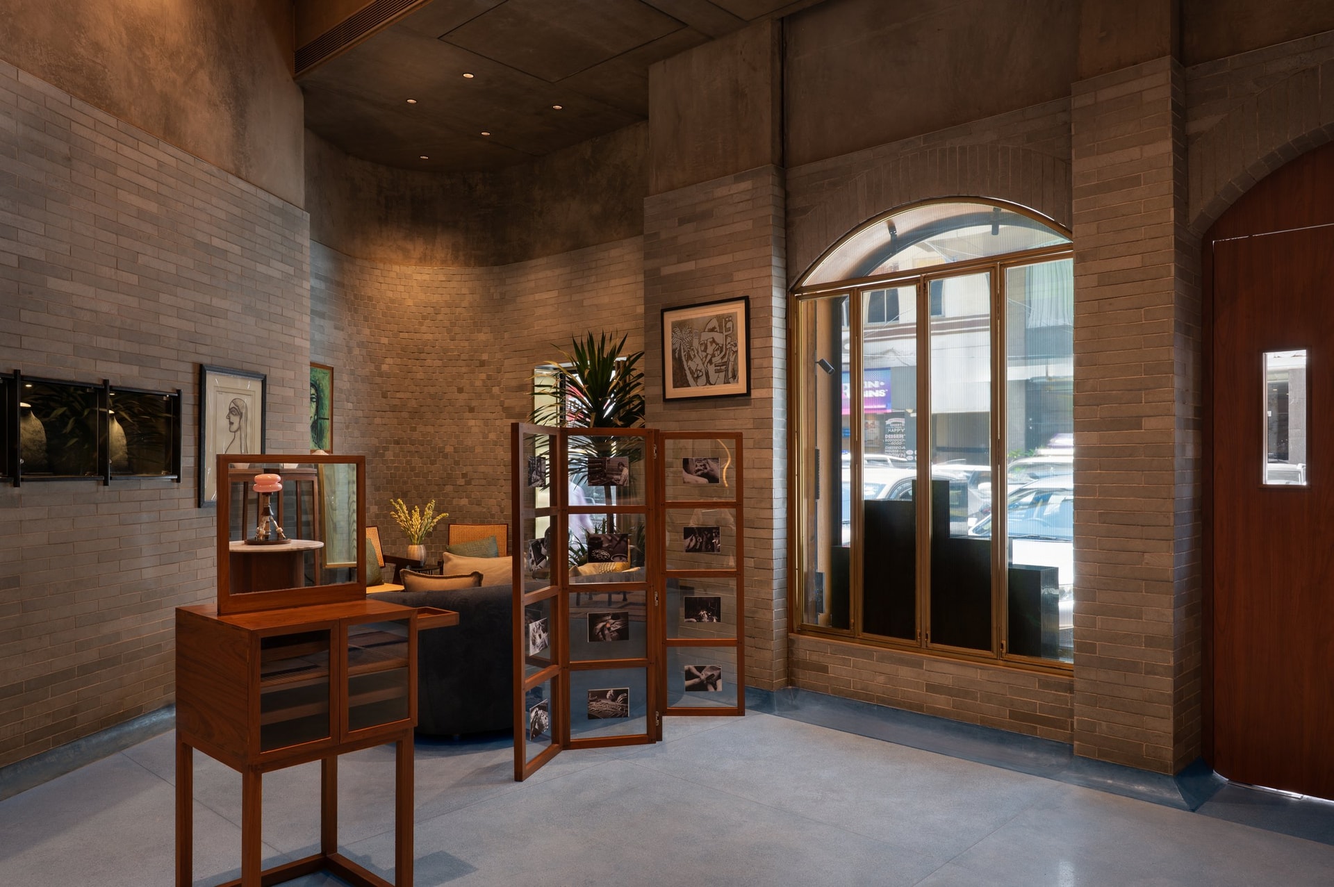 A seating vignette against the fine coursework of the handmade brick wall, softened by a folding photo screen