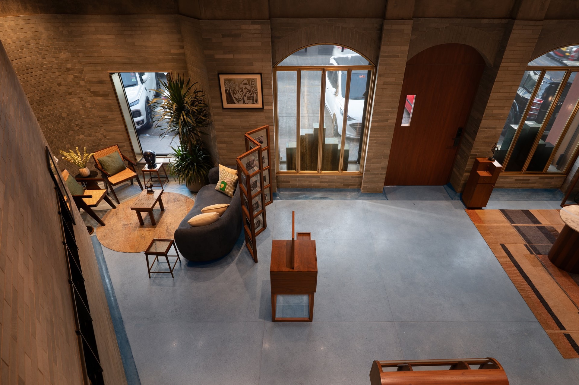 The main retail floor, arranged as a lounge with a curved sofa, caned lounge chairs, and portable timber-framed display