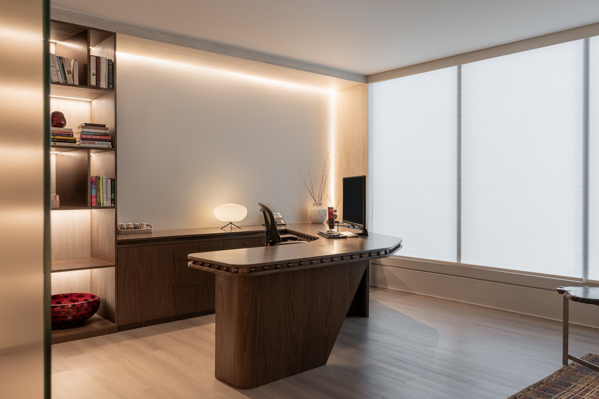 The cabin seen from the entry, where diffused light through a translucent shade fills a wall of walnut cabinetry