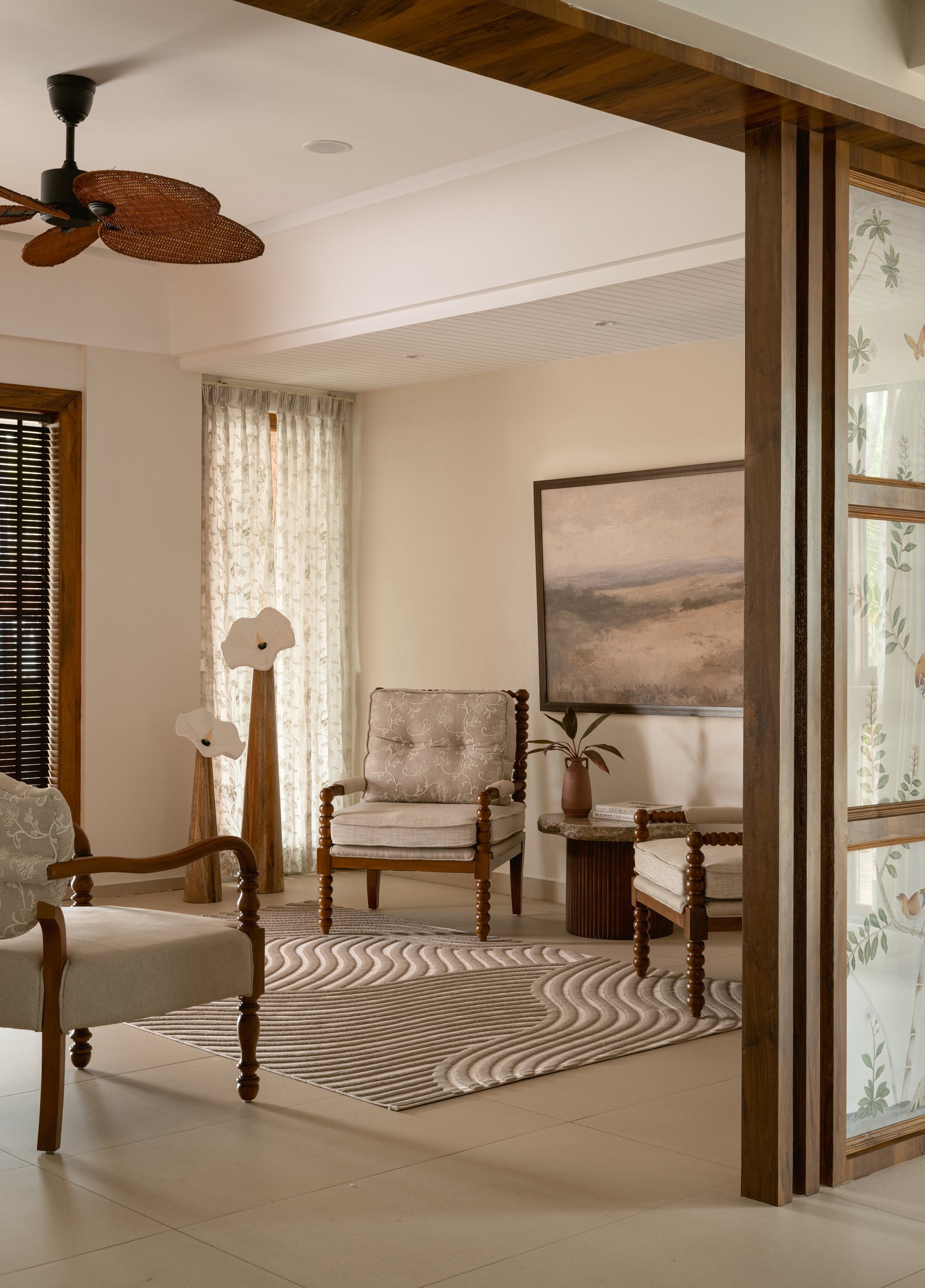 The formal living, where bobbin-turned furniture and a muted landscape painting establish the home's opening pause