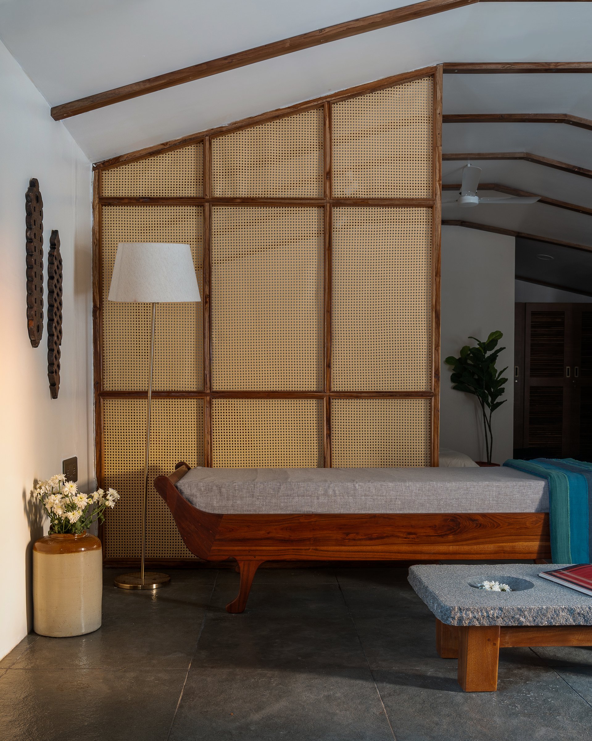 The cane-and-wood partition, framing the diwan while filtering light and air between living and sleeping zones