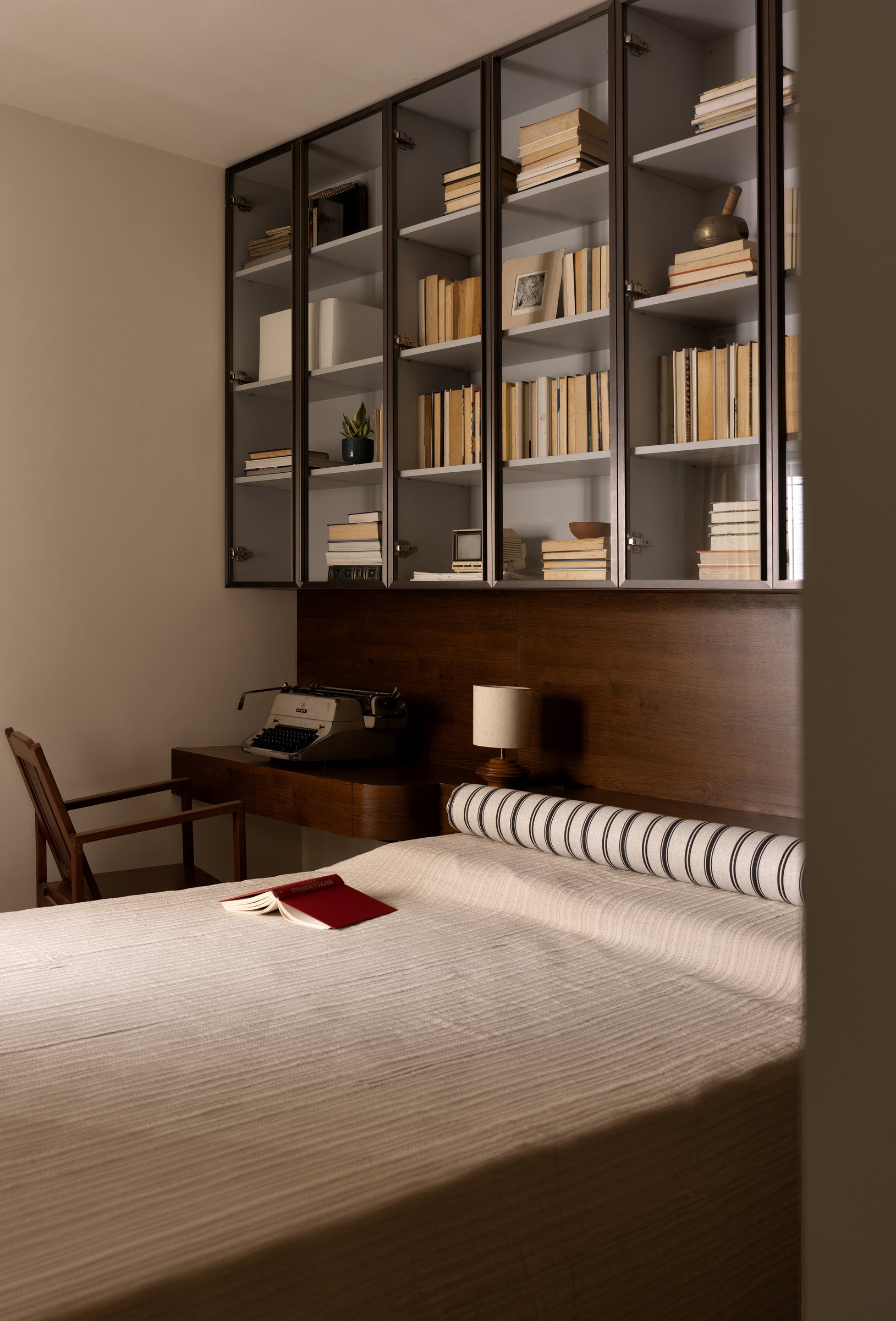 The son's room, designed around a collection of over 700 books held in a glass-fronted metal-framed cabinet