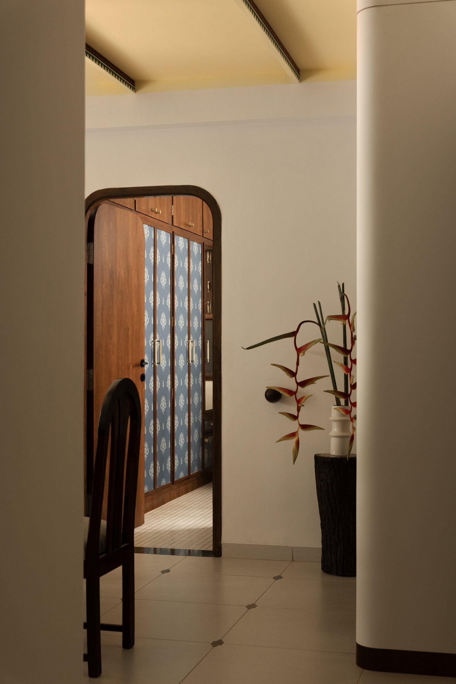 The passage to a secondary bedroom, where an ikat-patterned wardrobe in soft blue offers a glimpse of a different chromatic register