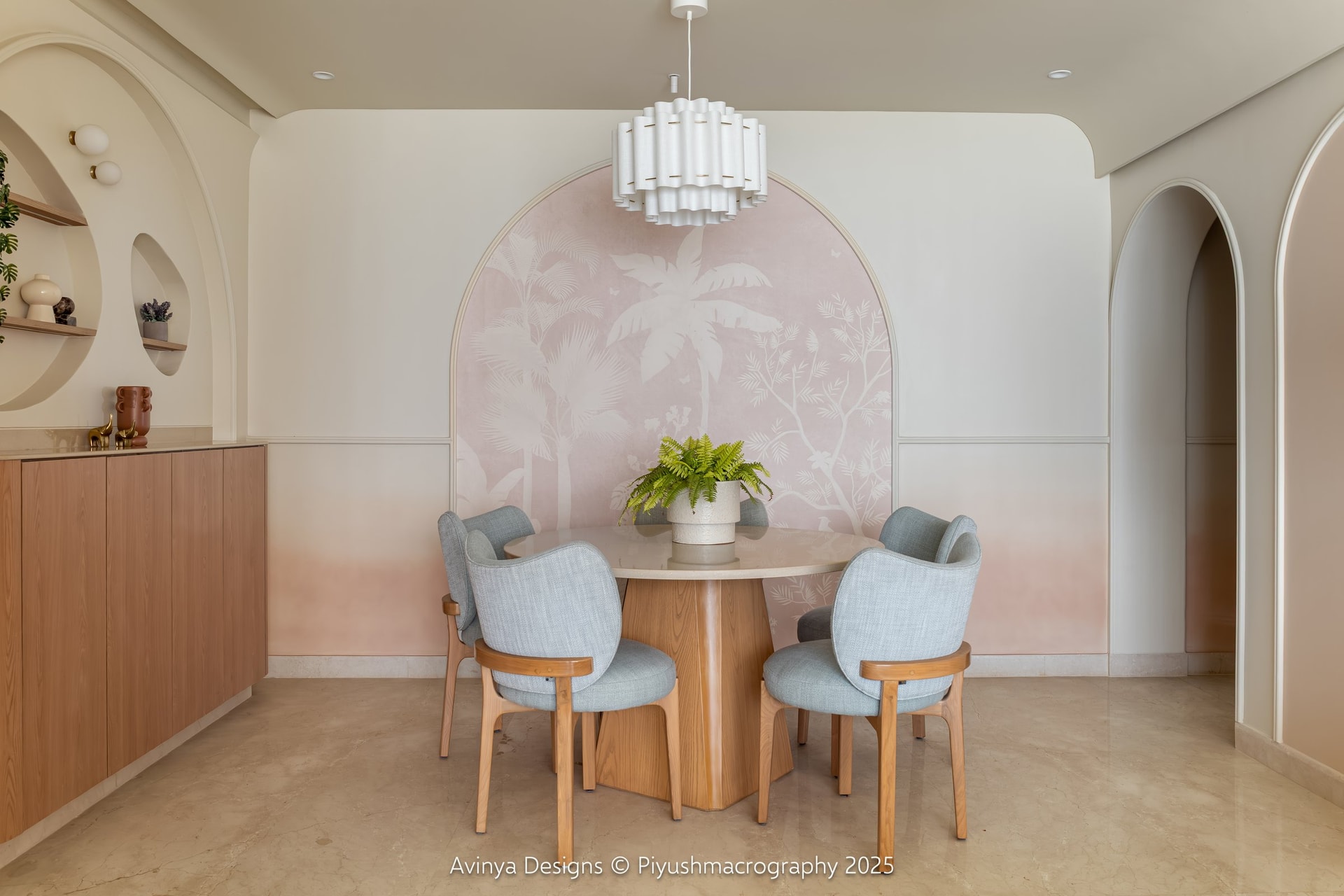 The dining area, where a hand painted tropical mural frames a round dining table beneath a fluted white pendant