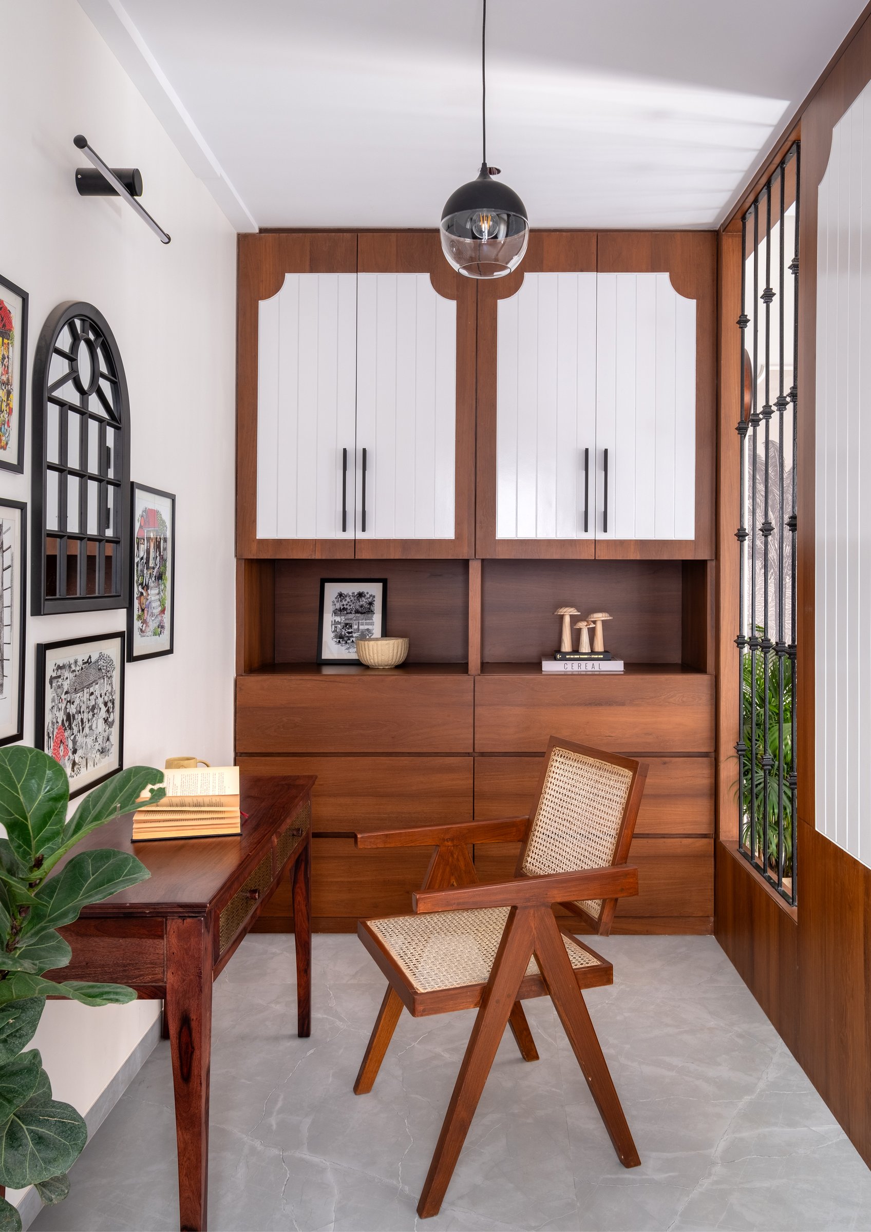 The study nook within the master bedroom, its wall of teak and white joinery paired with a cane-and-teak chair