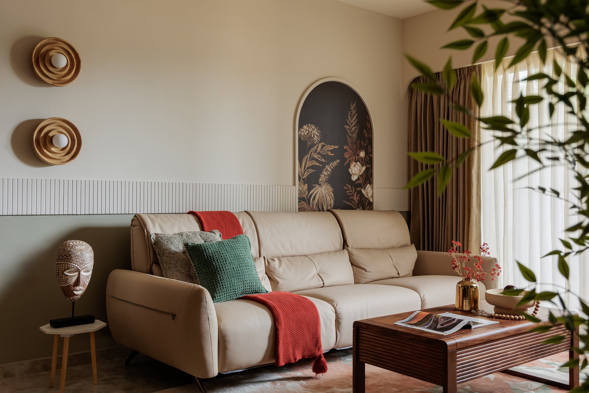The seating arrangement, where a pale leather sofa sits against a fluted panelled wall softened by a green wash below