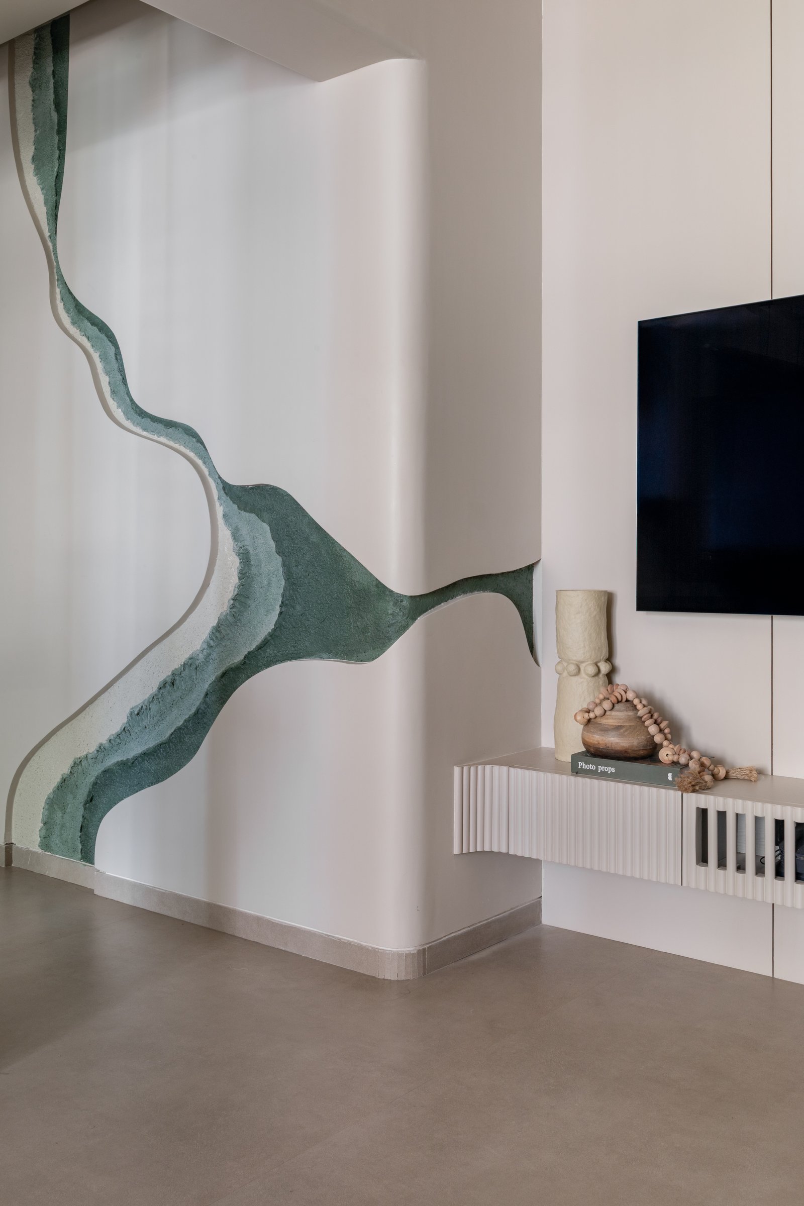 The green mural moves from the living wall into the passage, becoming the home's connective thread