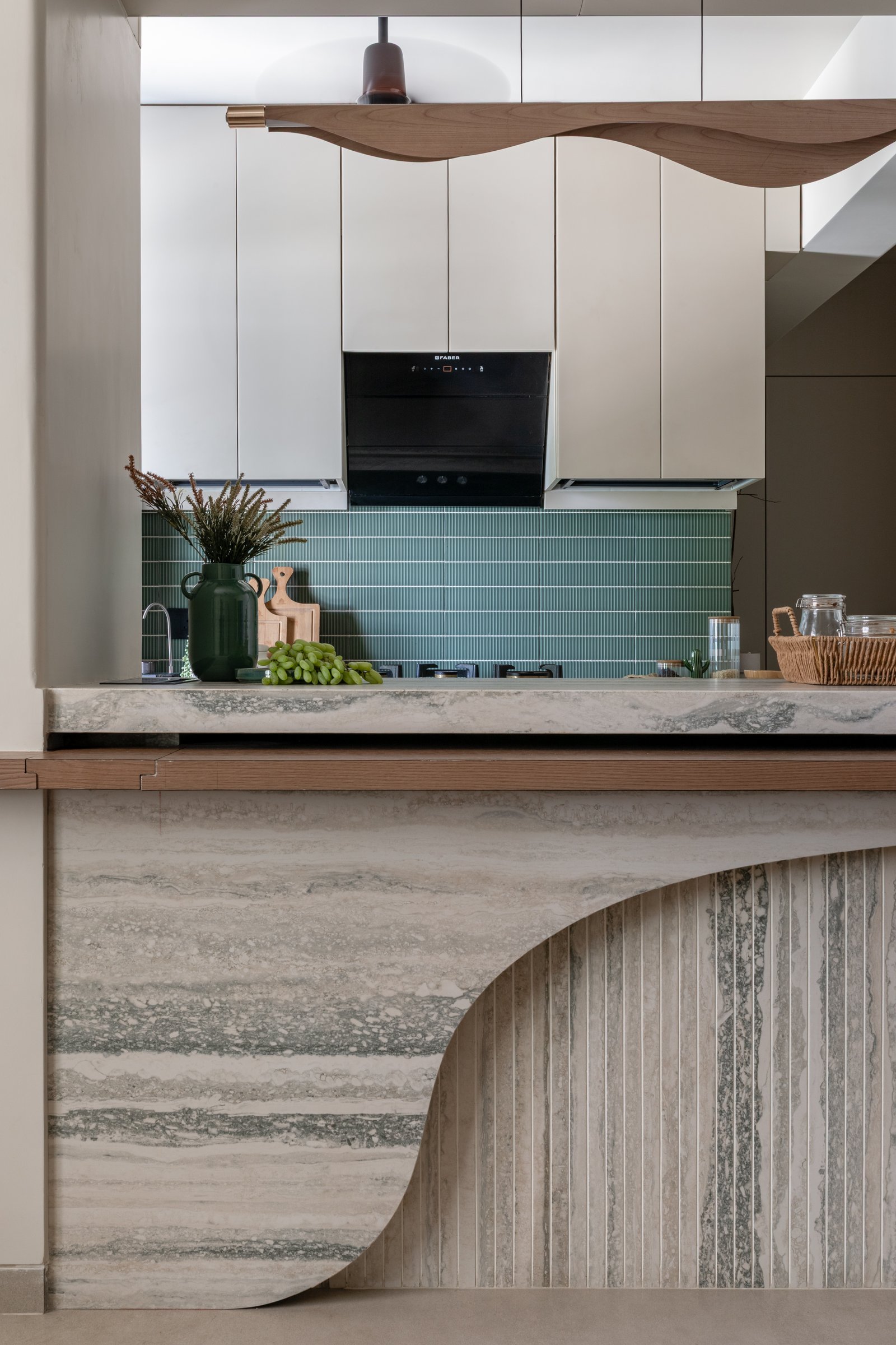 The island's fluted stone front, its curved reveal reading almost as drapery frozen in cross-section