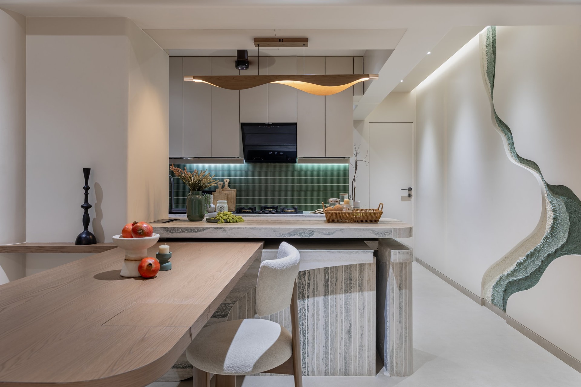 The kitchen and dining zone, where a curved stone island meets a suspended wooden wave overhead