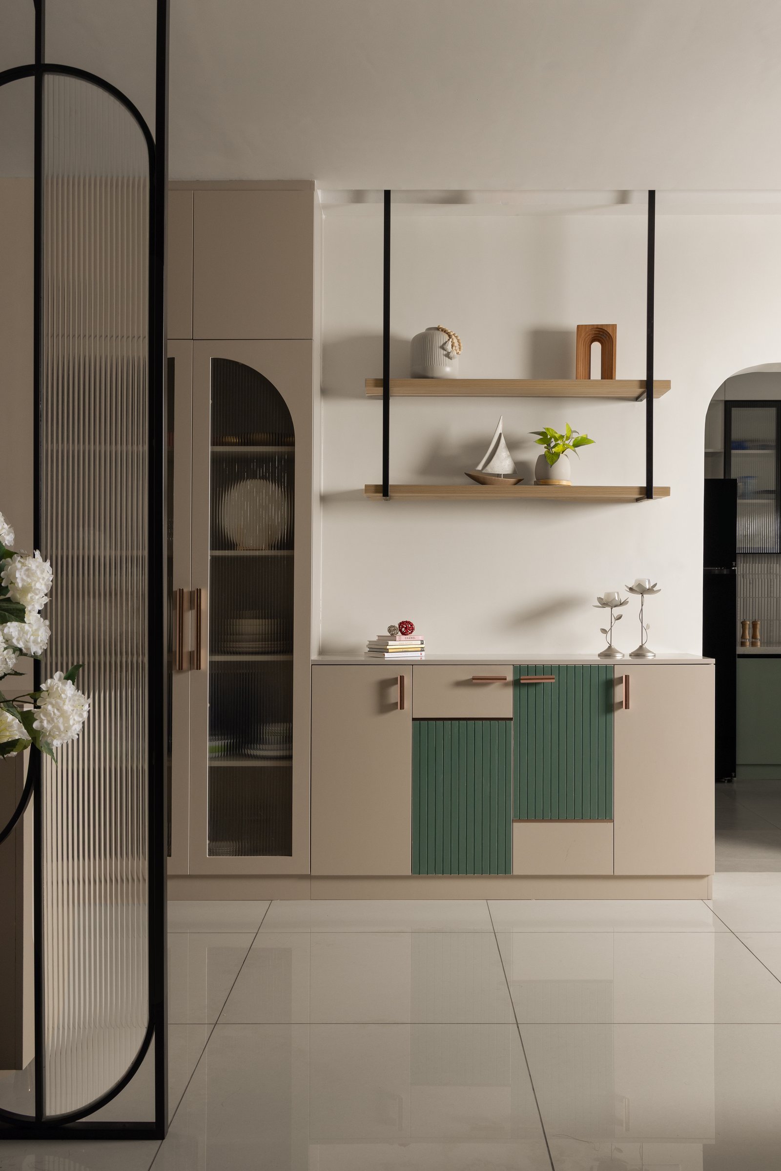 A secondary storage wall extending the home's colour-blocking with fluted green inserts and a tall reeded-glass vitrine