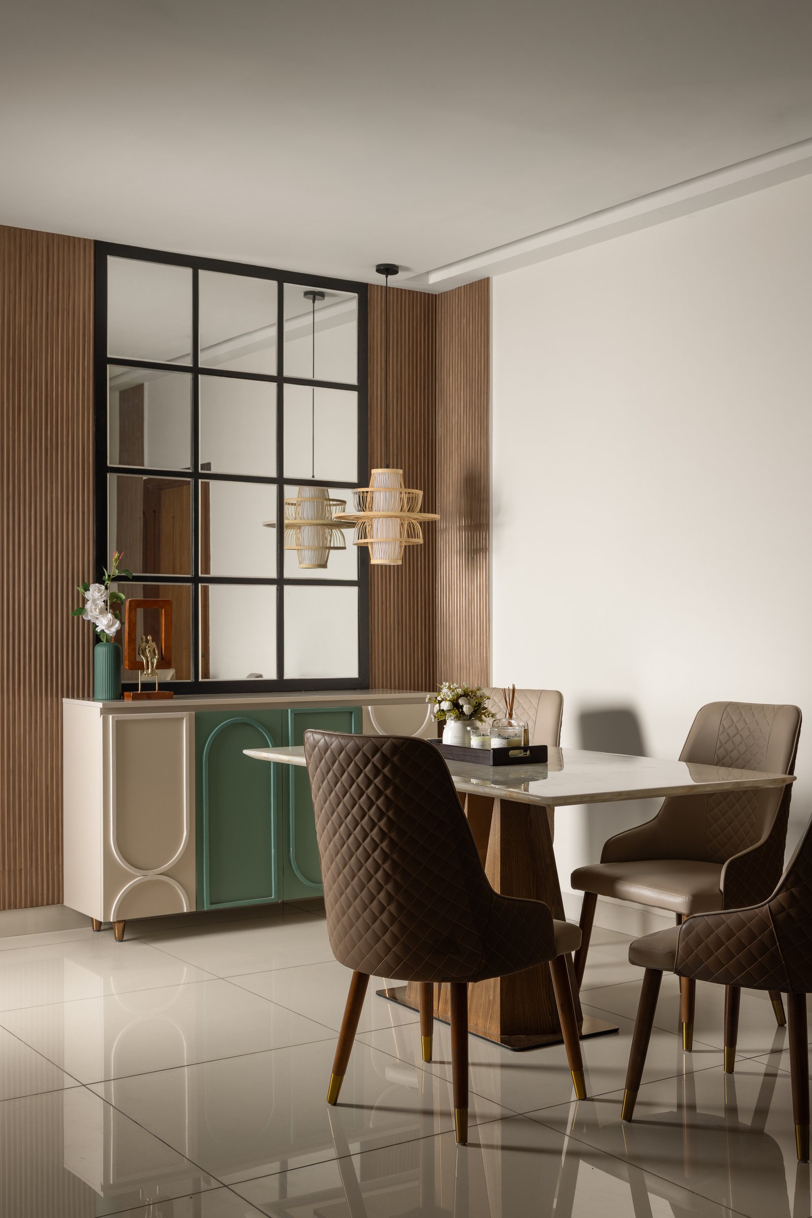 The dining area, anchored by a custom ivory-and-green crockery console beneath a grid-mirrored panel that satisfies Vastu while doubling the room's volume