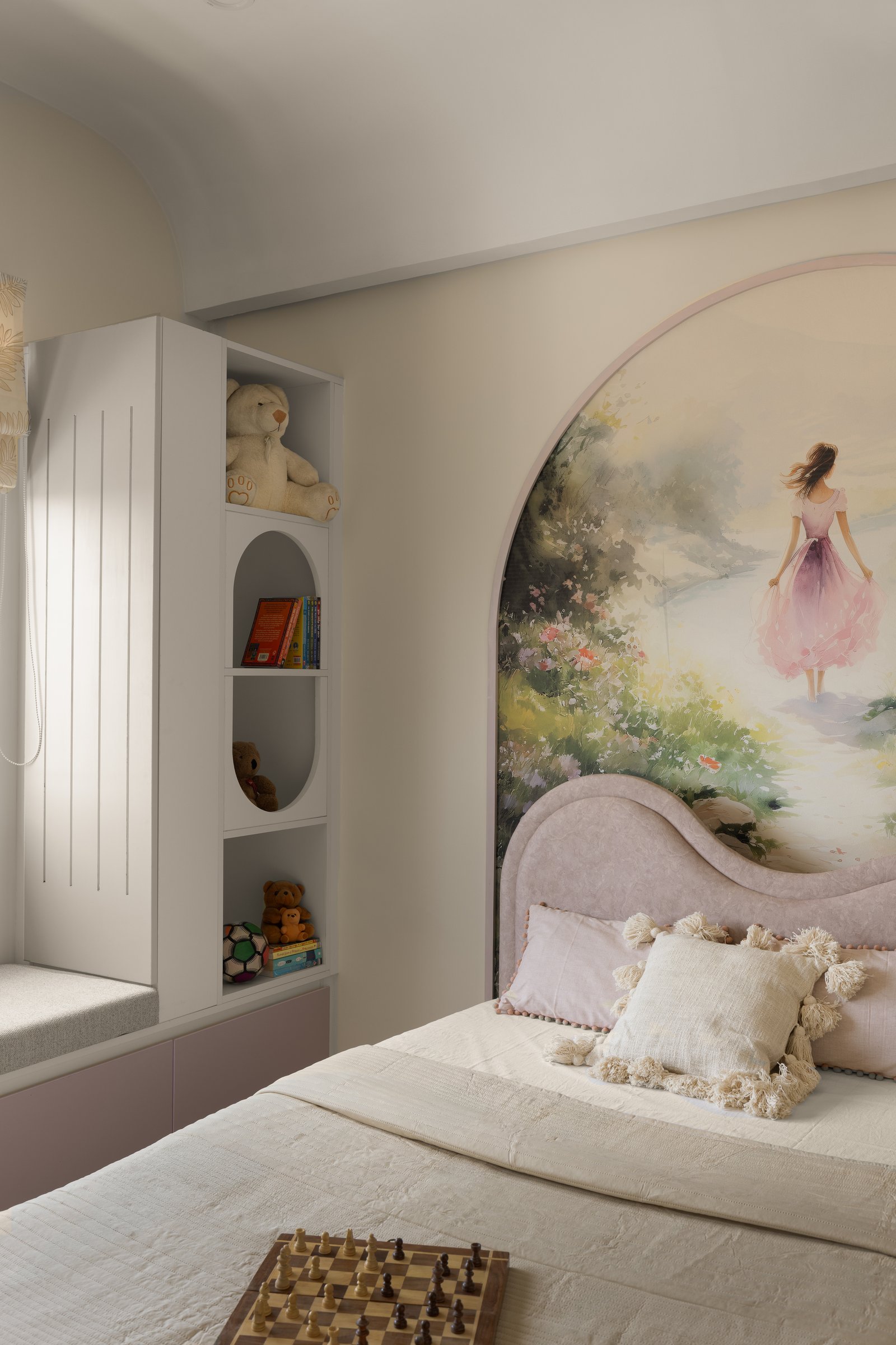 The daughter's room, its arched garden mural framed within the recess behind a scalloped blush headboard