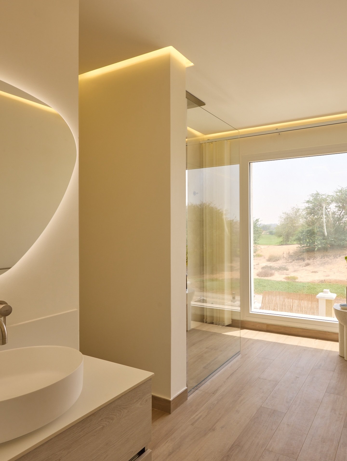 A sculptural partition wall organises the bathroom without severing its zones.