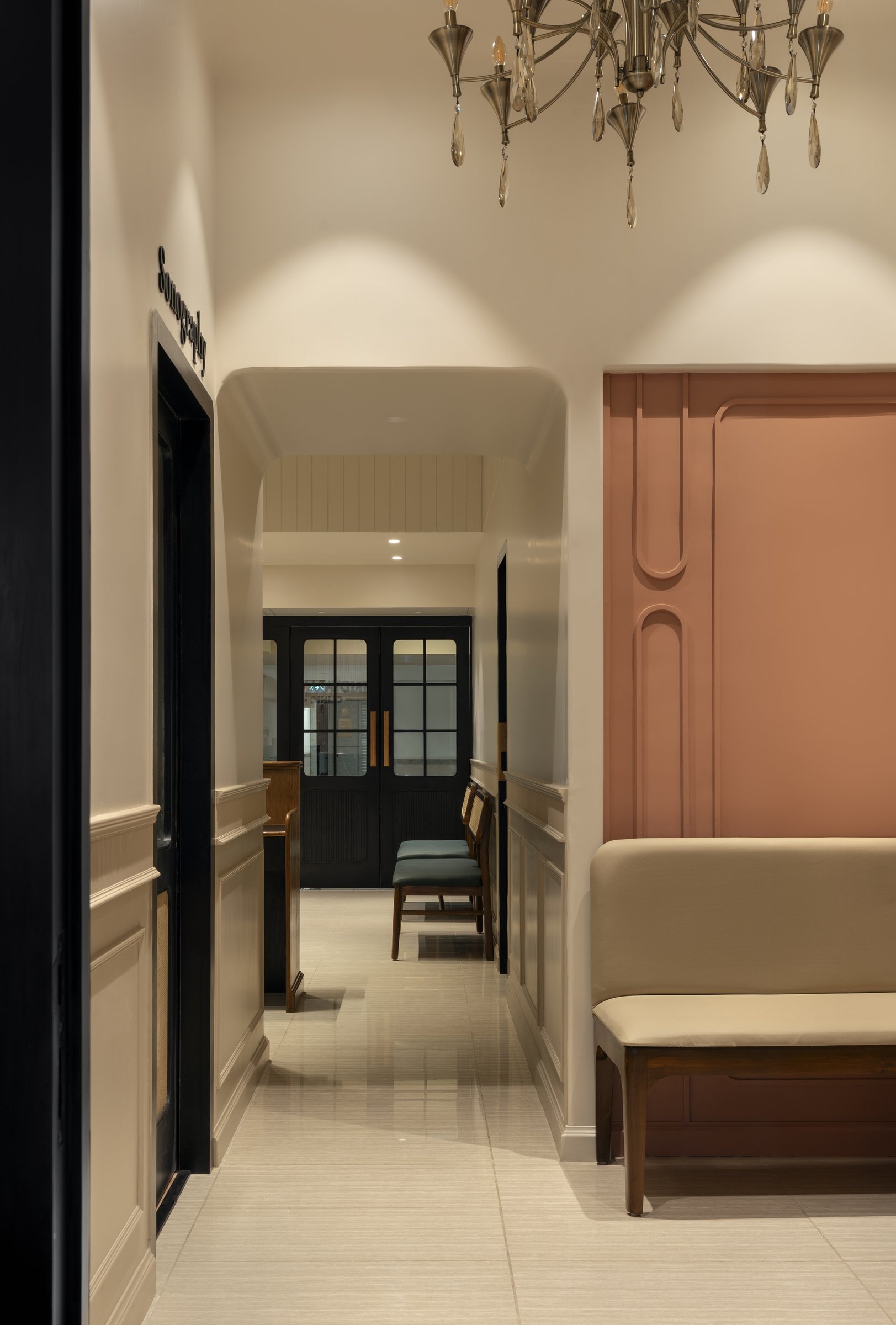 The corridor, where moulded wainscoting and a terracotta relief panel soften the passage between consulting rooms