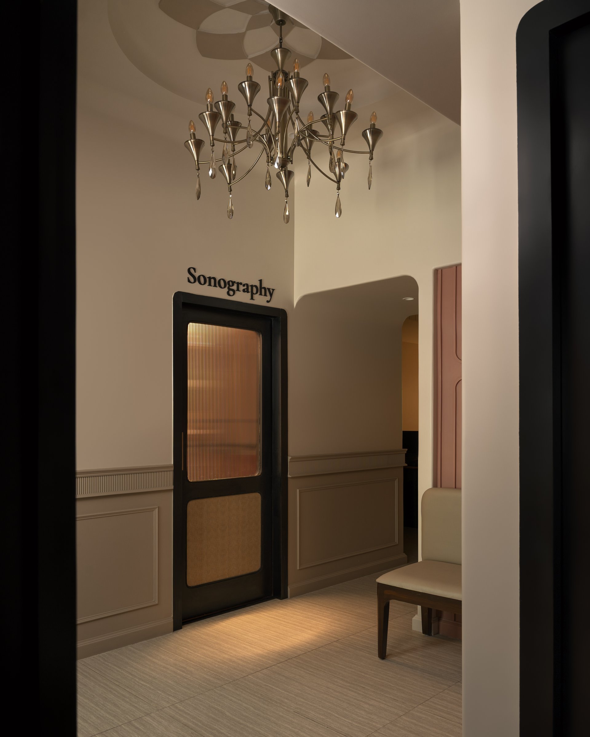 The chandelier above the sonography threshold, where ornament and utility are held in deliberate balance