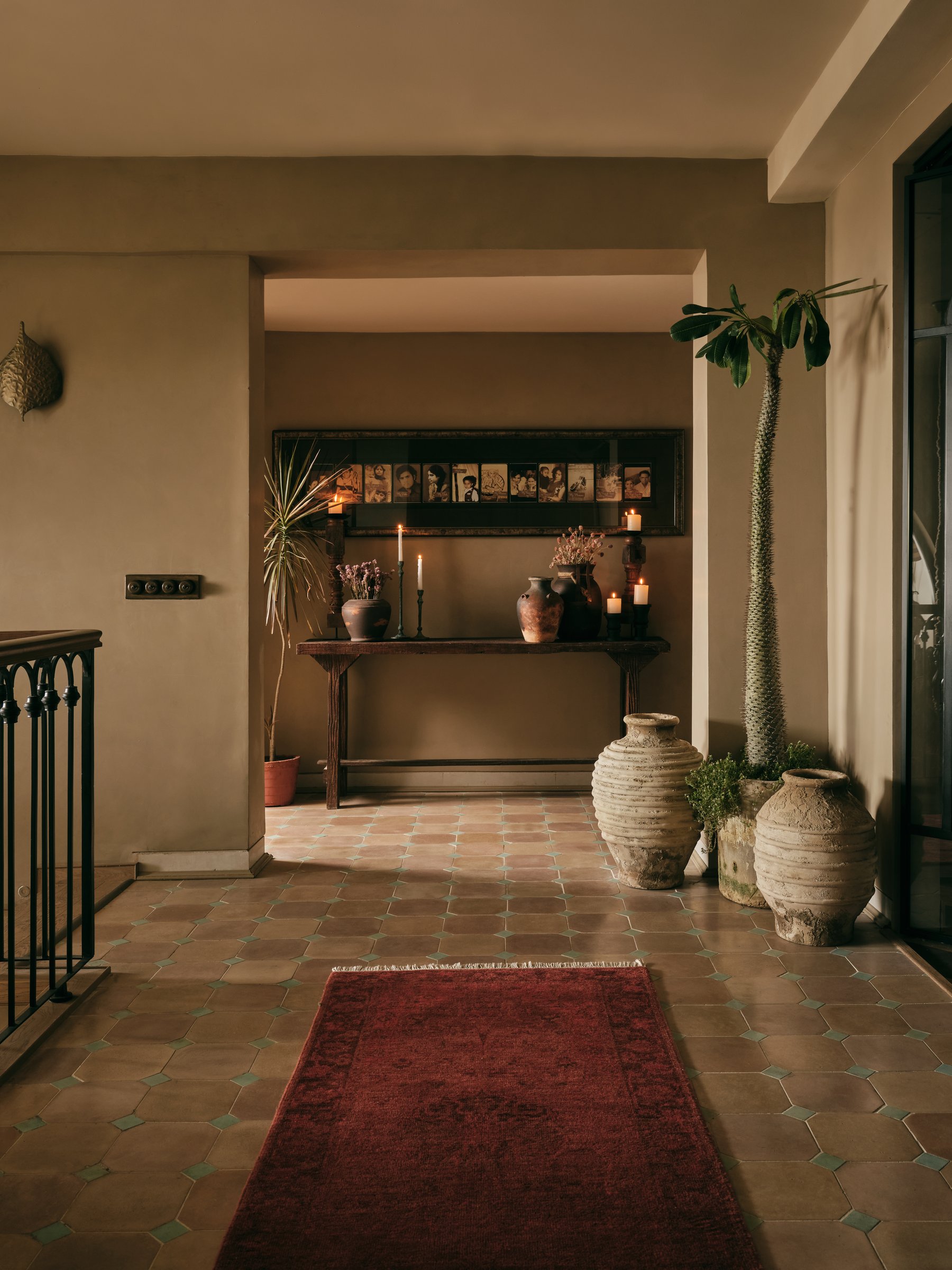 The entry corridor, where a checkered terracotta-and-green floor and a layered console set the home's collected register
