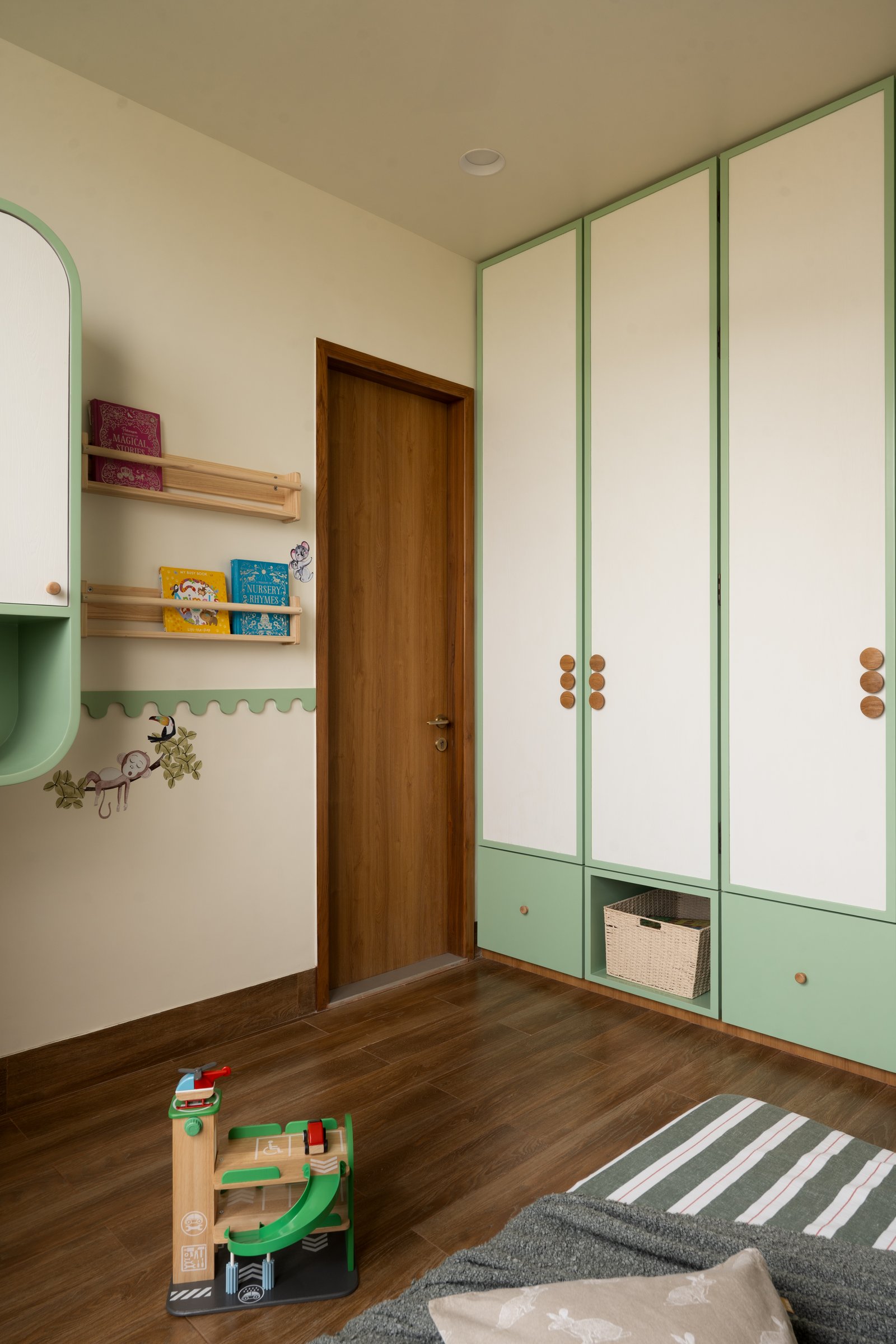 The children's wardrobe, its pale panelled doors and small round timber pulls scaled to daily rhythms