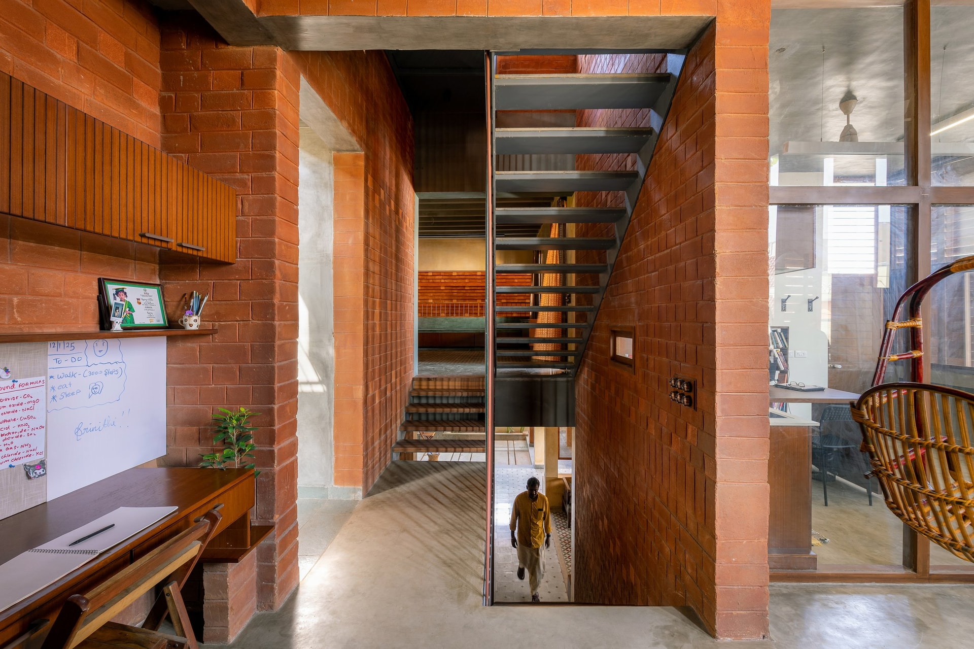 The study, set within a fully brick-lined volume with a suspended cane chair