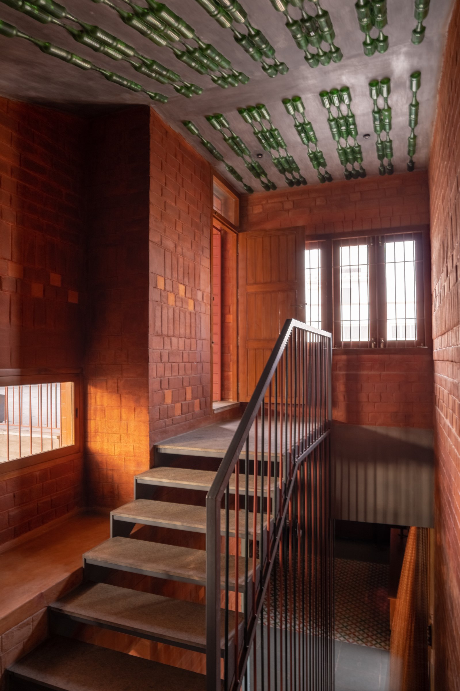 The stair, its ceiling composed of green glass bottles set into concrete