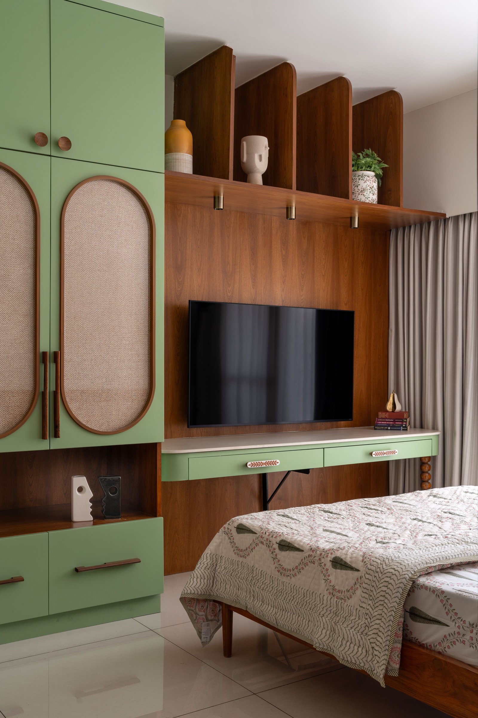 The joinery wall opposite, where sage lacquer and warm wood veneer stage the room's mid-century inflection