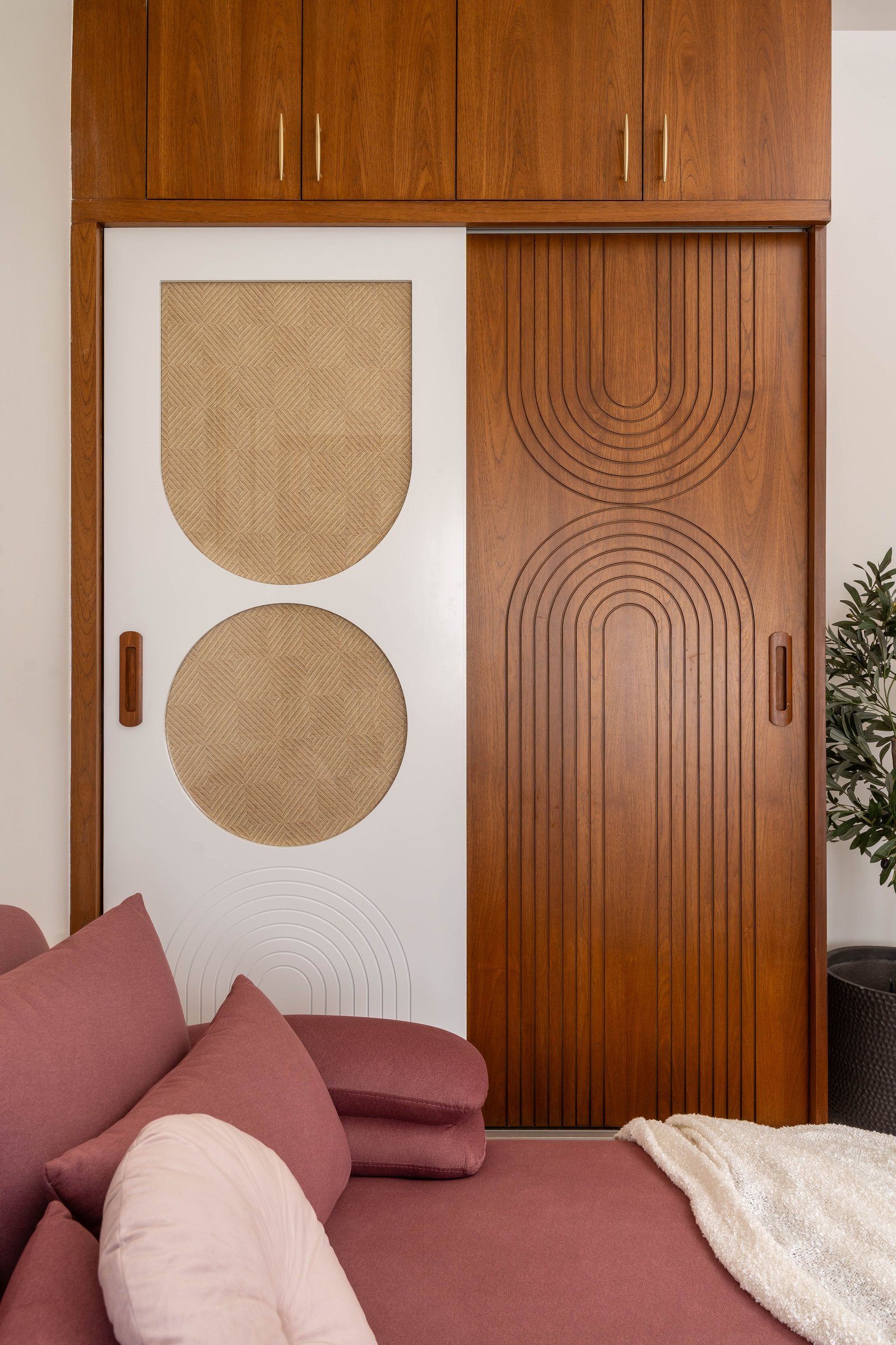 A joinery detail, where routed arches in warm wood and cane insets distill the home's design language