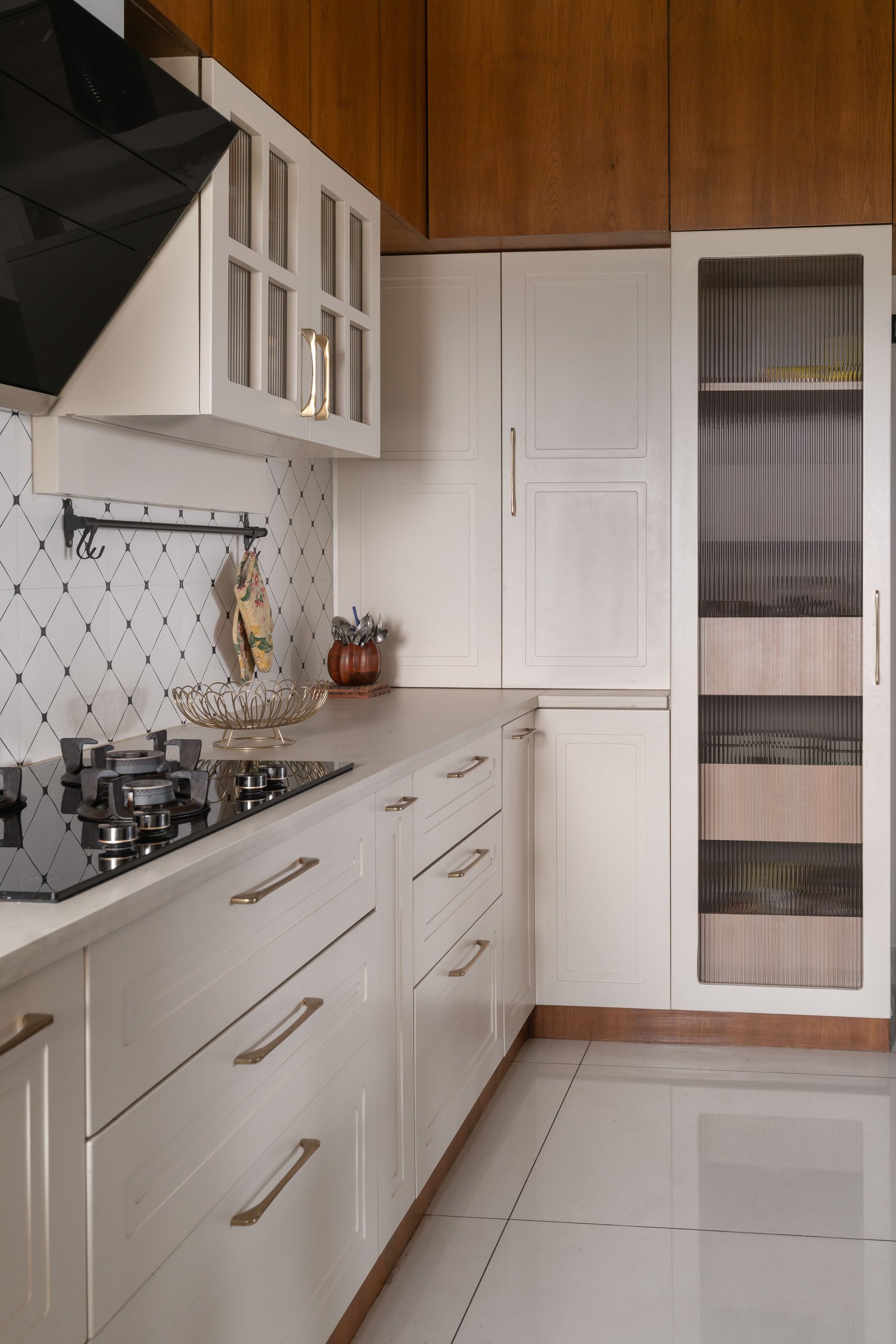 A perpendicular run of the kitchen, where reeded glass tempers the classical raised-panel discipline