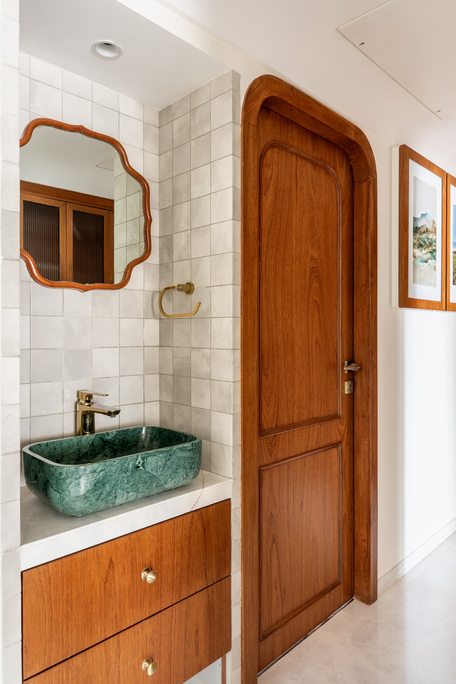 The guest washroom, where a green stone vessel basin sits above a slim teak drawer unit