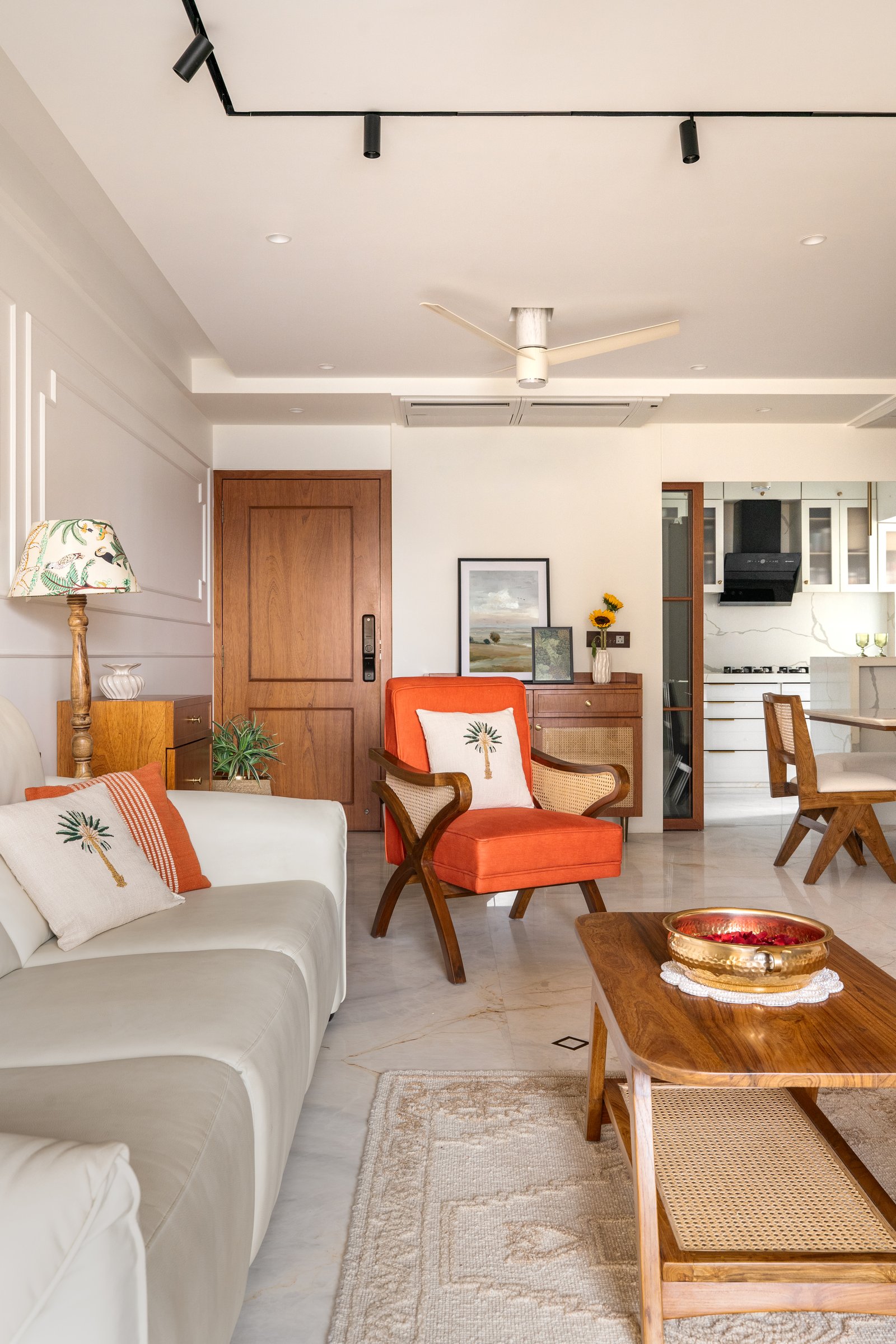 Looking back toward the entry, the living room resolves into a single social spine that extends toward the kitchen and dining