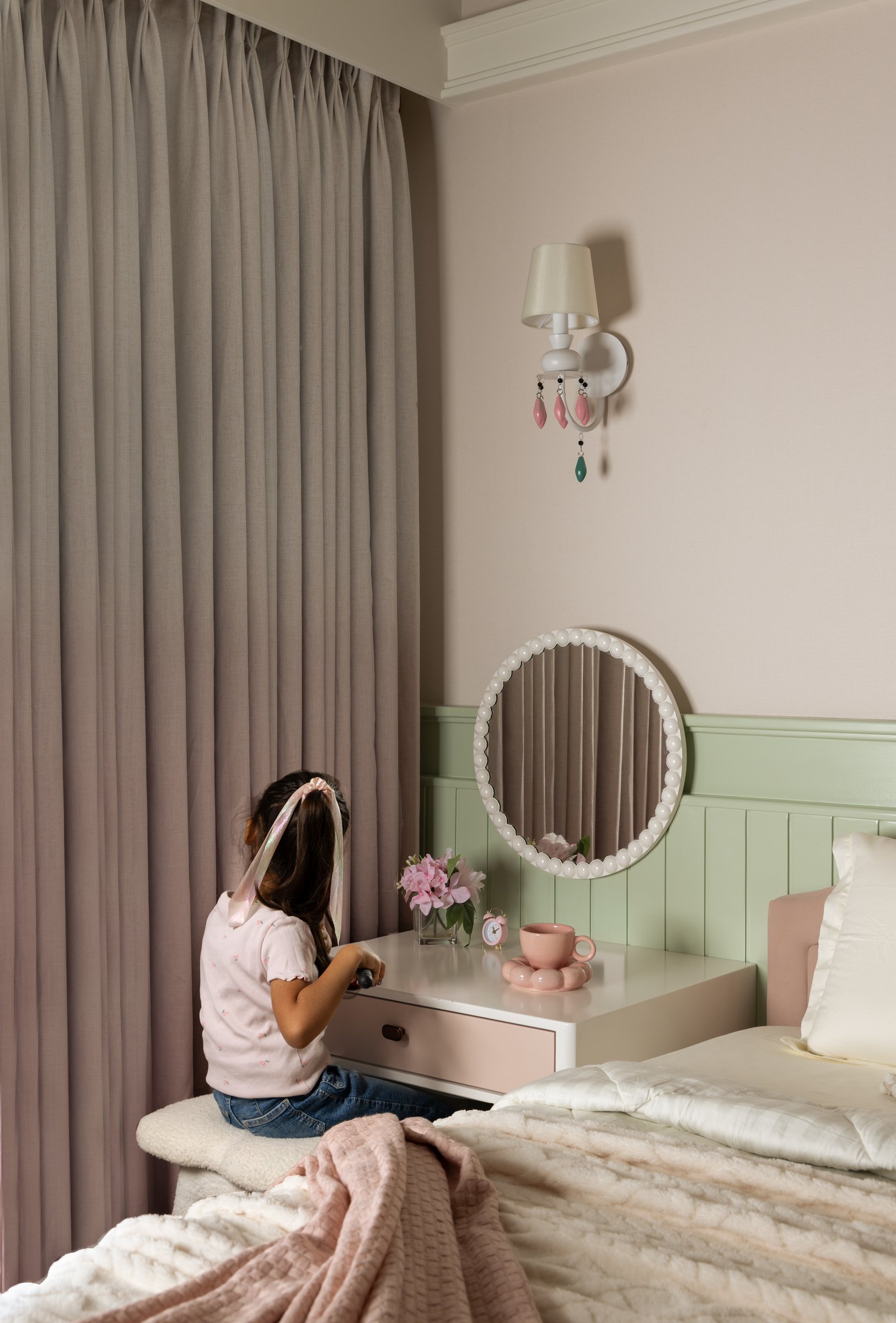 Sage-green wainscoting and a beaded mirror at the daughters’ vanity ledge