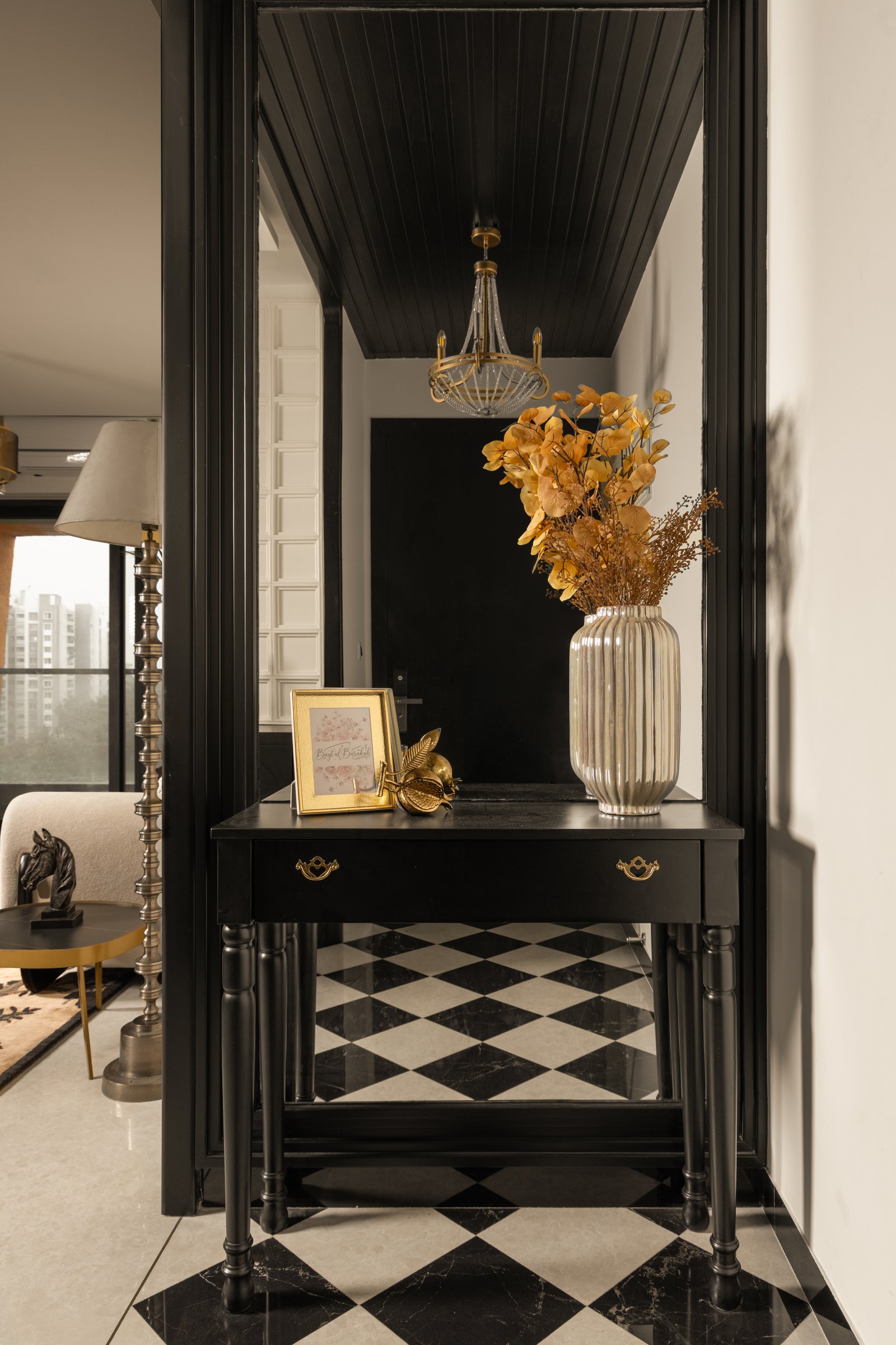 The foyer, where a black-panelled console and a diamond-patterned floor set the home’s decompressive tone