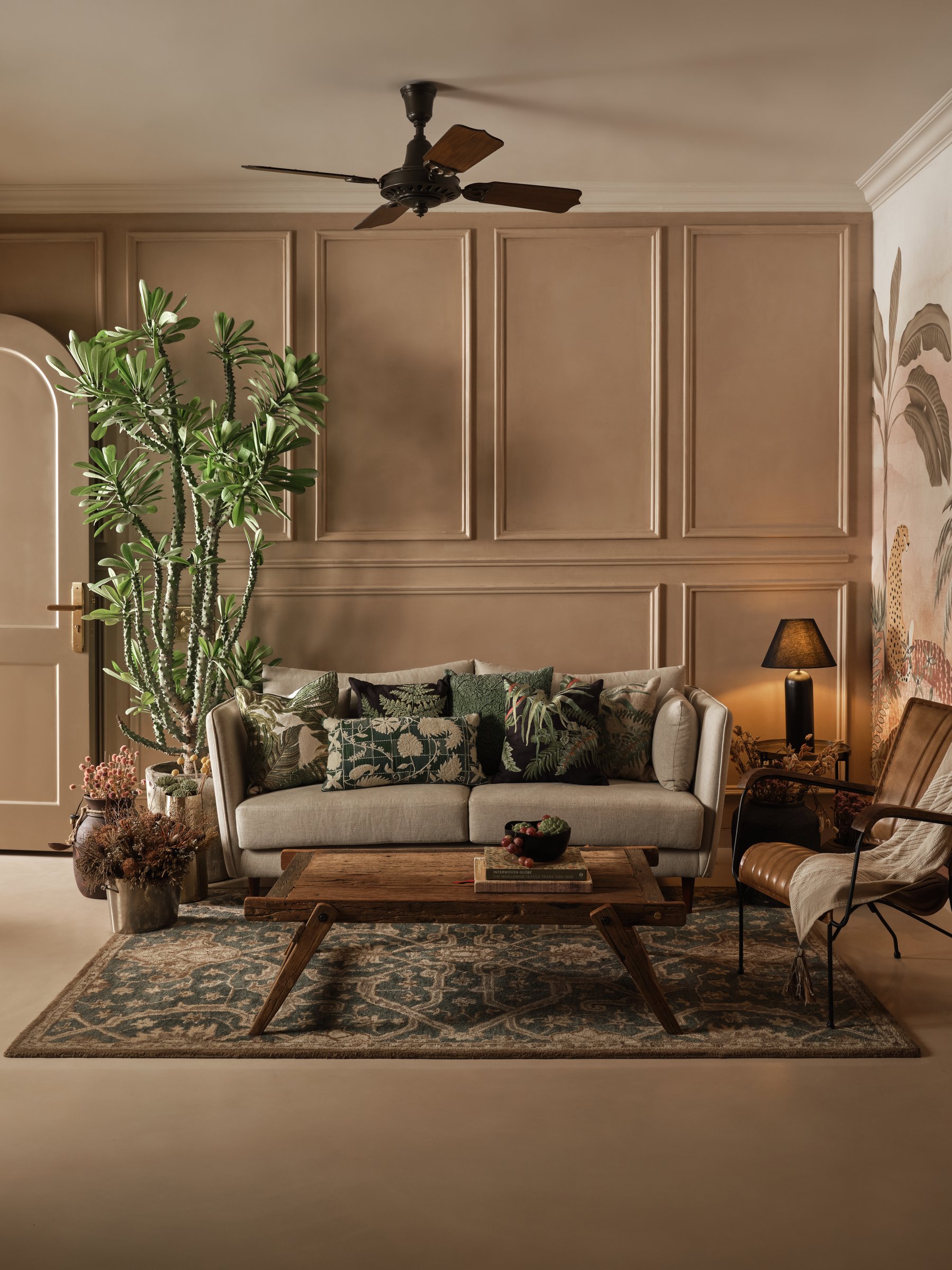 The guest lounge, where panelled taupe walls preview the tropical mural in the adjoining bedroom