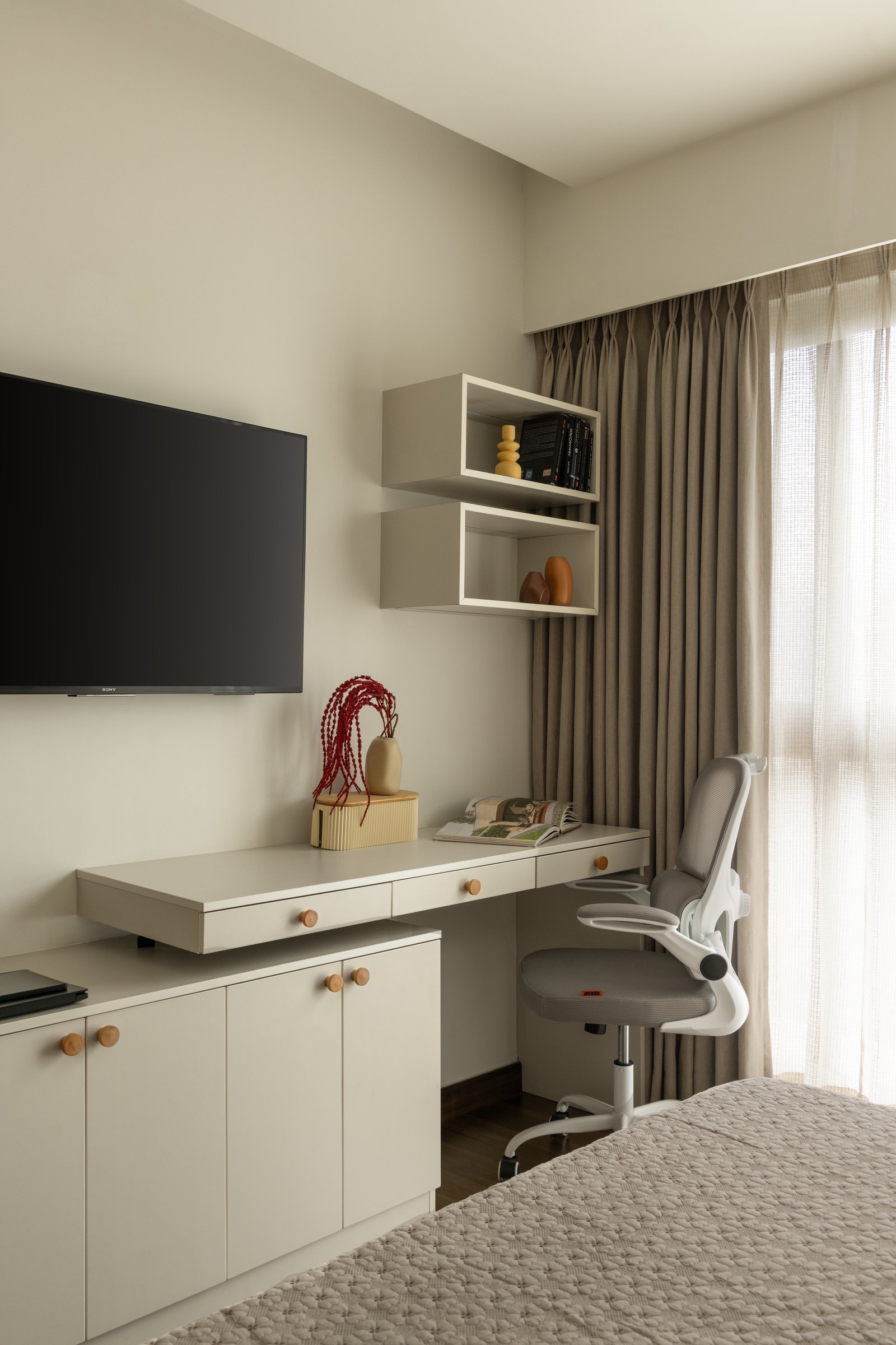 A compact work zone in the guest bedroom, folding desk and shelving into a single composition