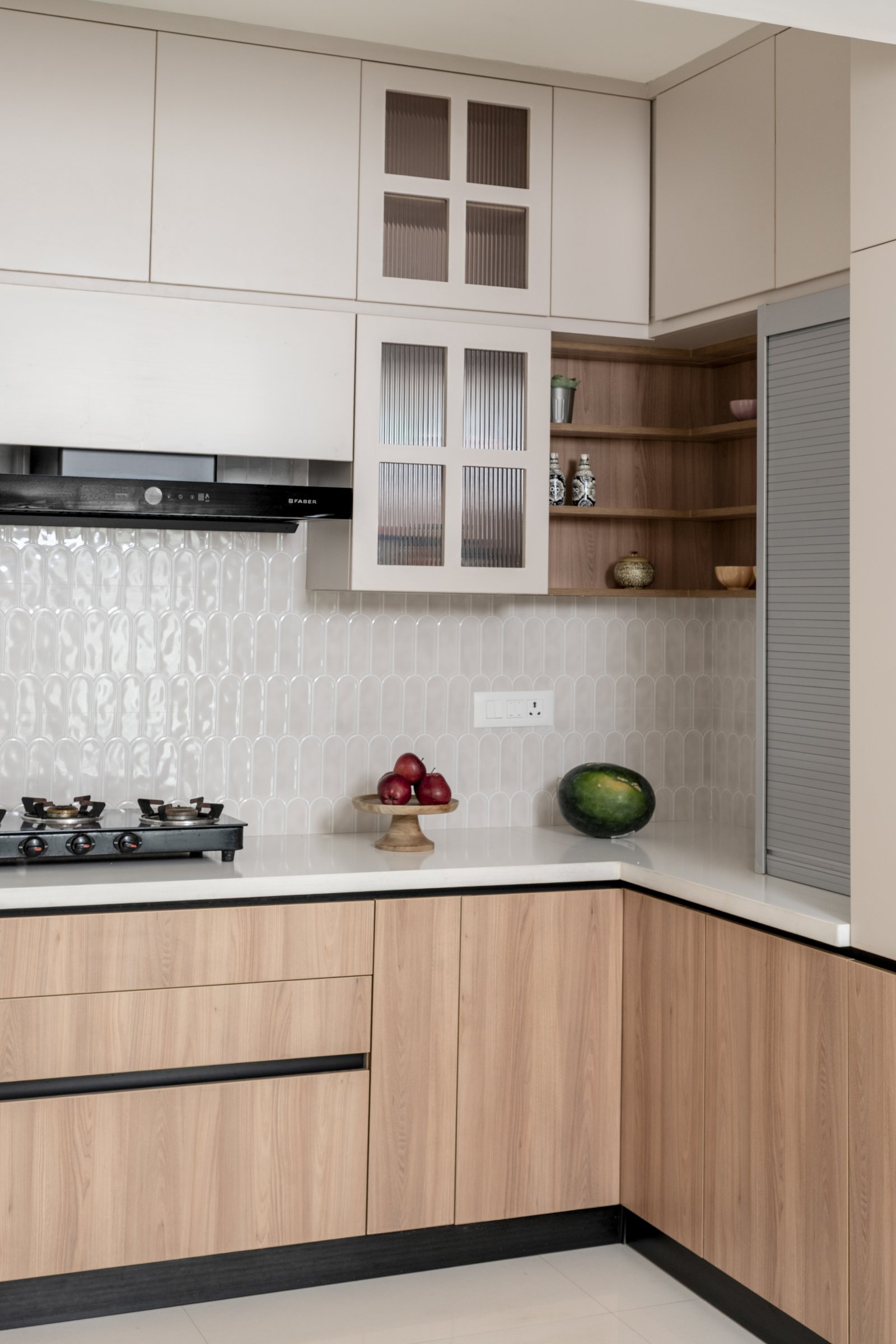 The arched picket tile backsplash, softening the geometry of an otherwise crisply organised workstation