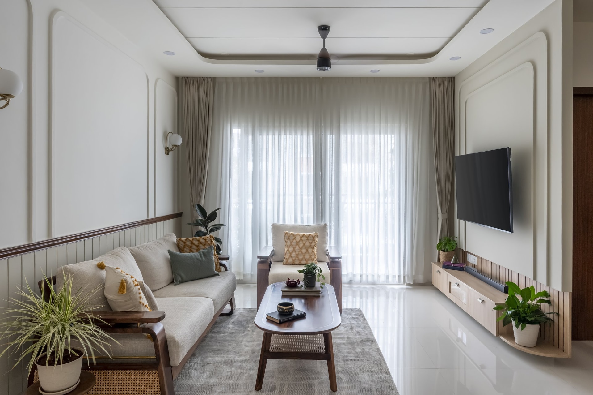 The living room along its length, where slatted wainscot and a timber rail establish a quiet architectural datum
