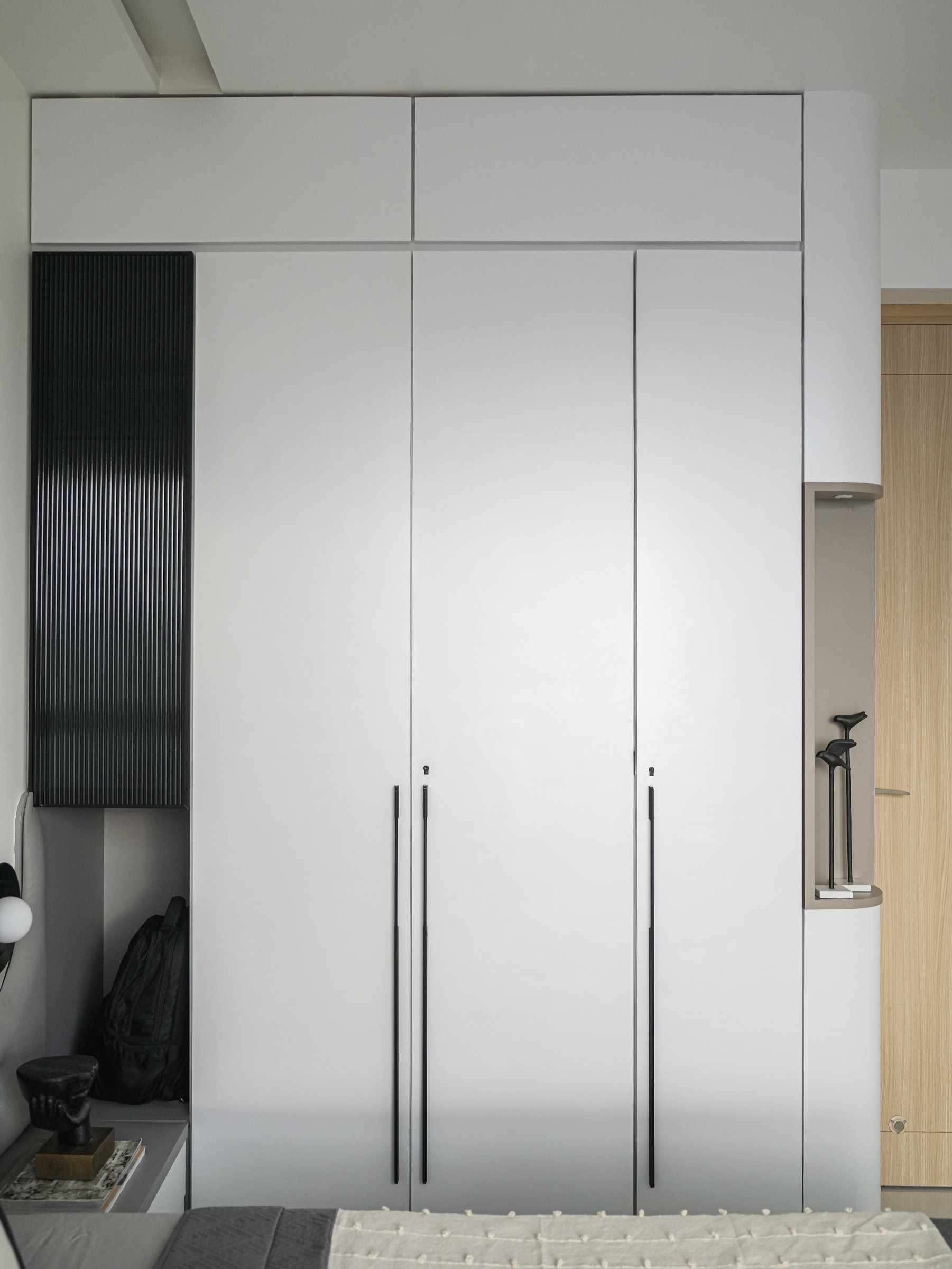 Three tall matte panels, articulated by slim vertical black pulls, demonstrate how much restraint can achieve