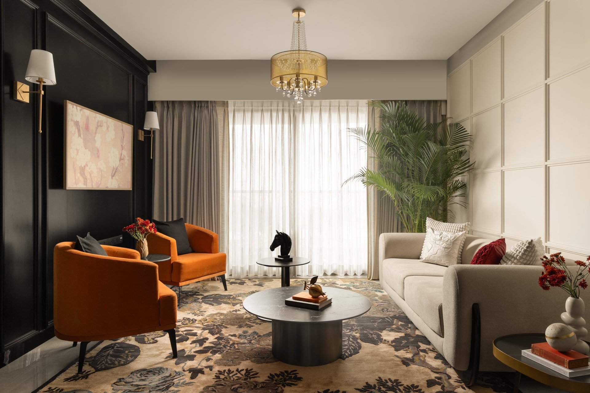 The living room, where a black feature wall meets a pale panelled surround, held in balance by rust velvet armchairs