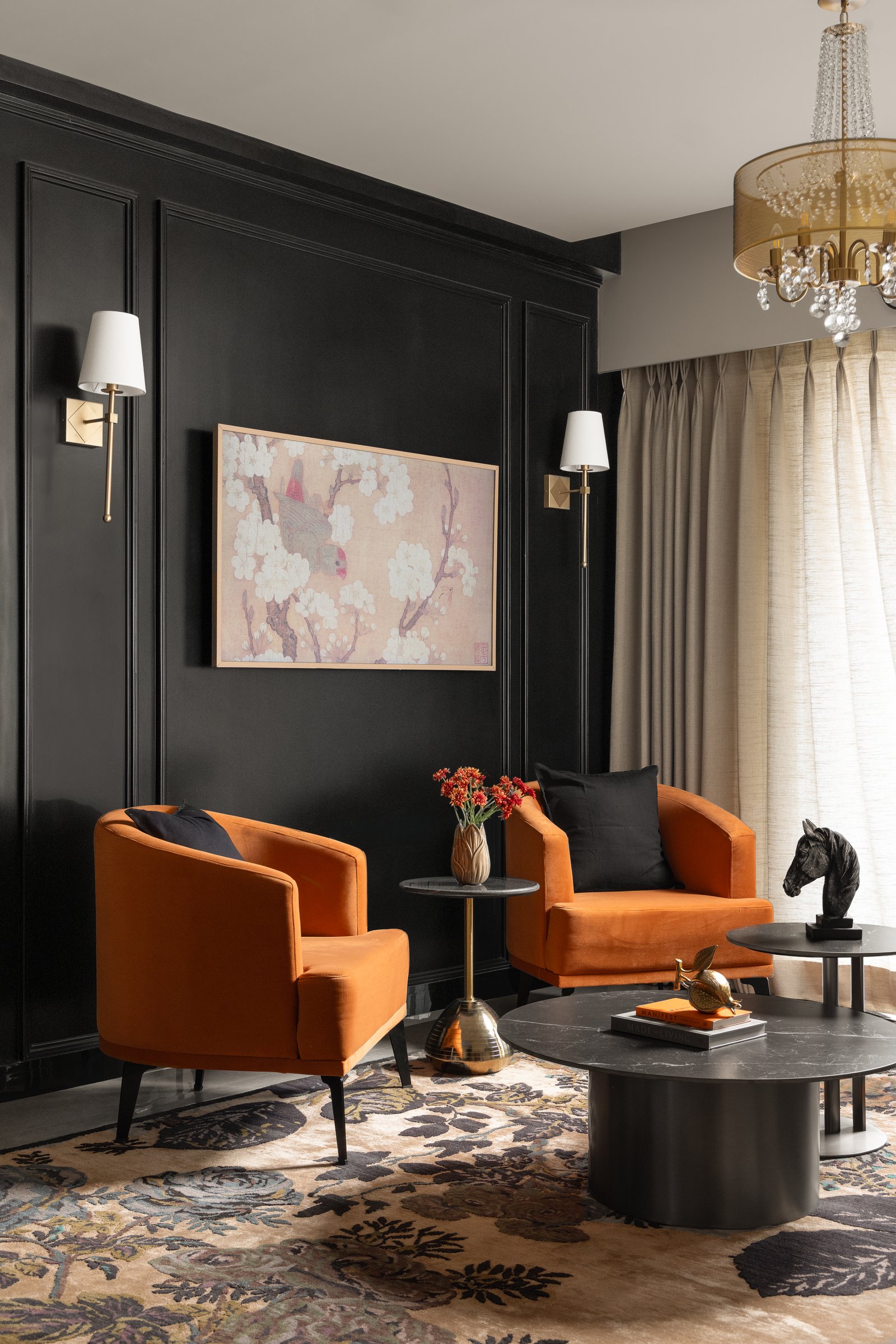 A closer view of the seating group: burnt-orange velvet against deep matte-black panelling