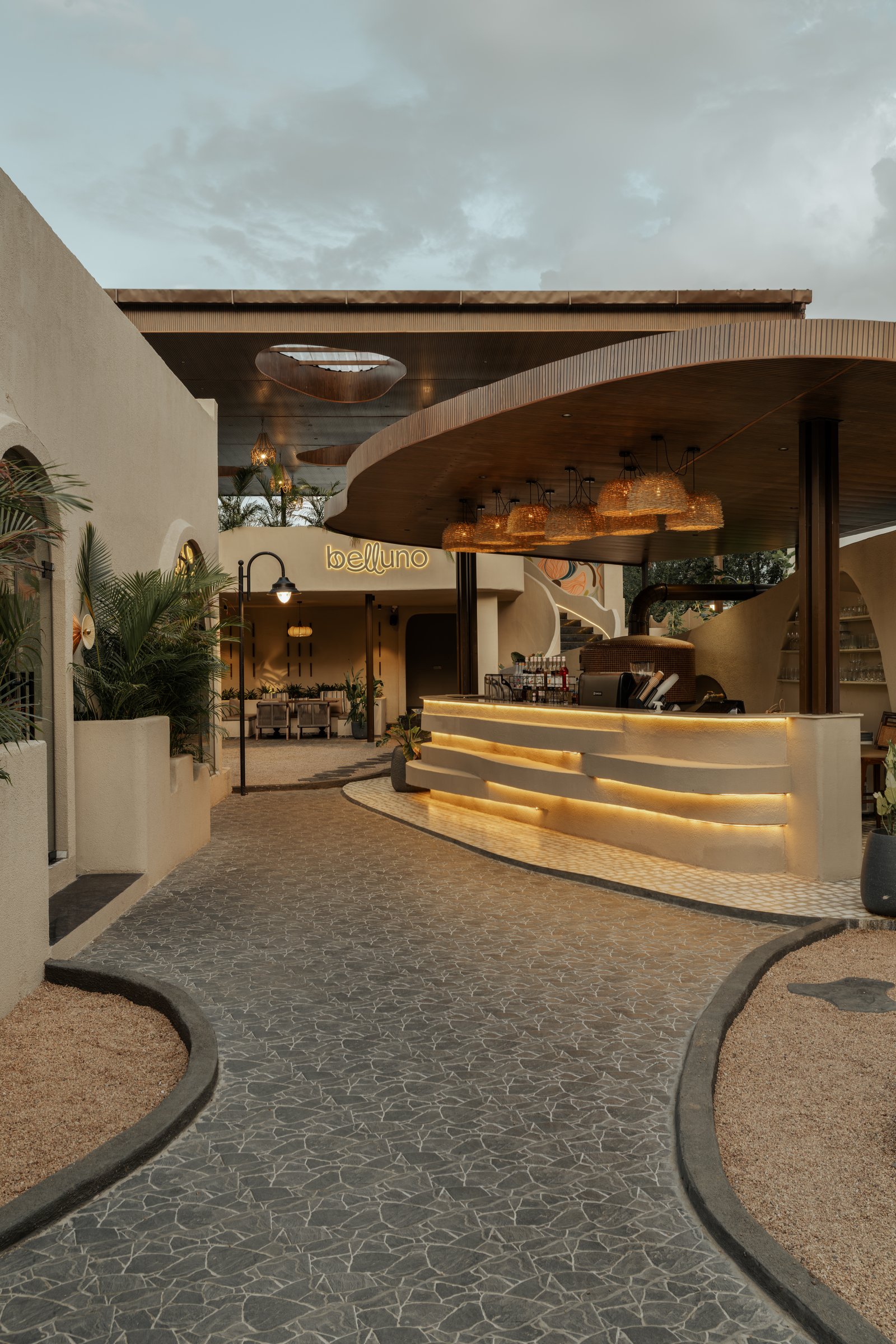 The arrival passage, where a fluted service counter and a cantilevered timber-slatted canopy anchor the arrival sequence