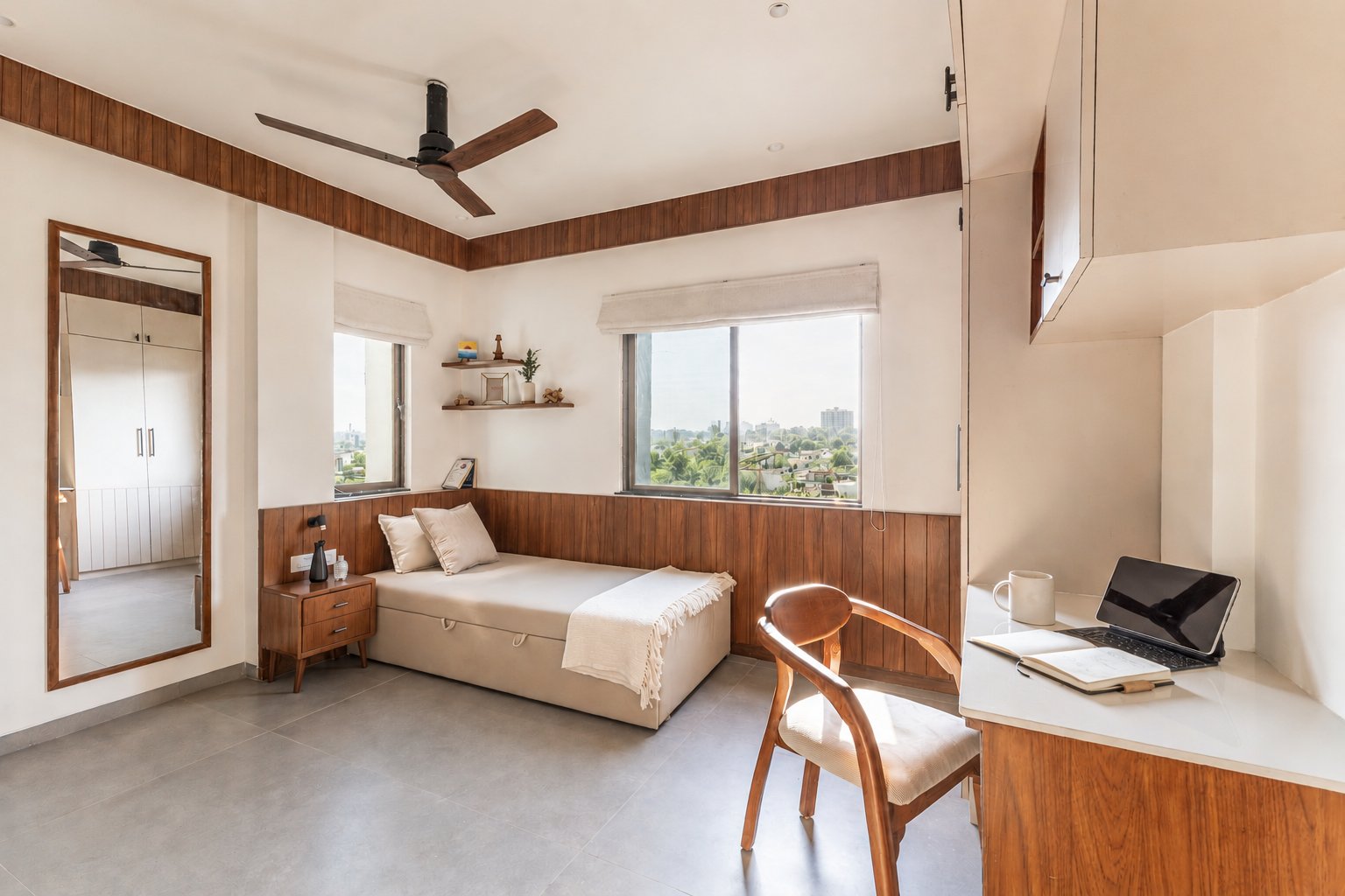 The study-and-guest room, where a continuous wooden dado integrates counter, shelves, and daybed