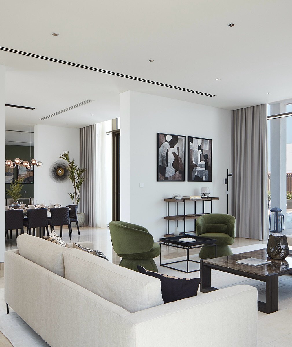 The living area extends toward the dining zone, separated by a freestanding wall of paired abstract prints.