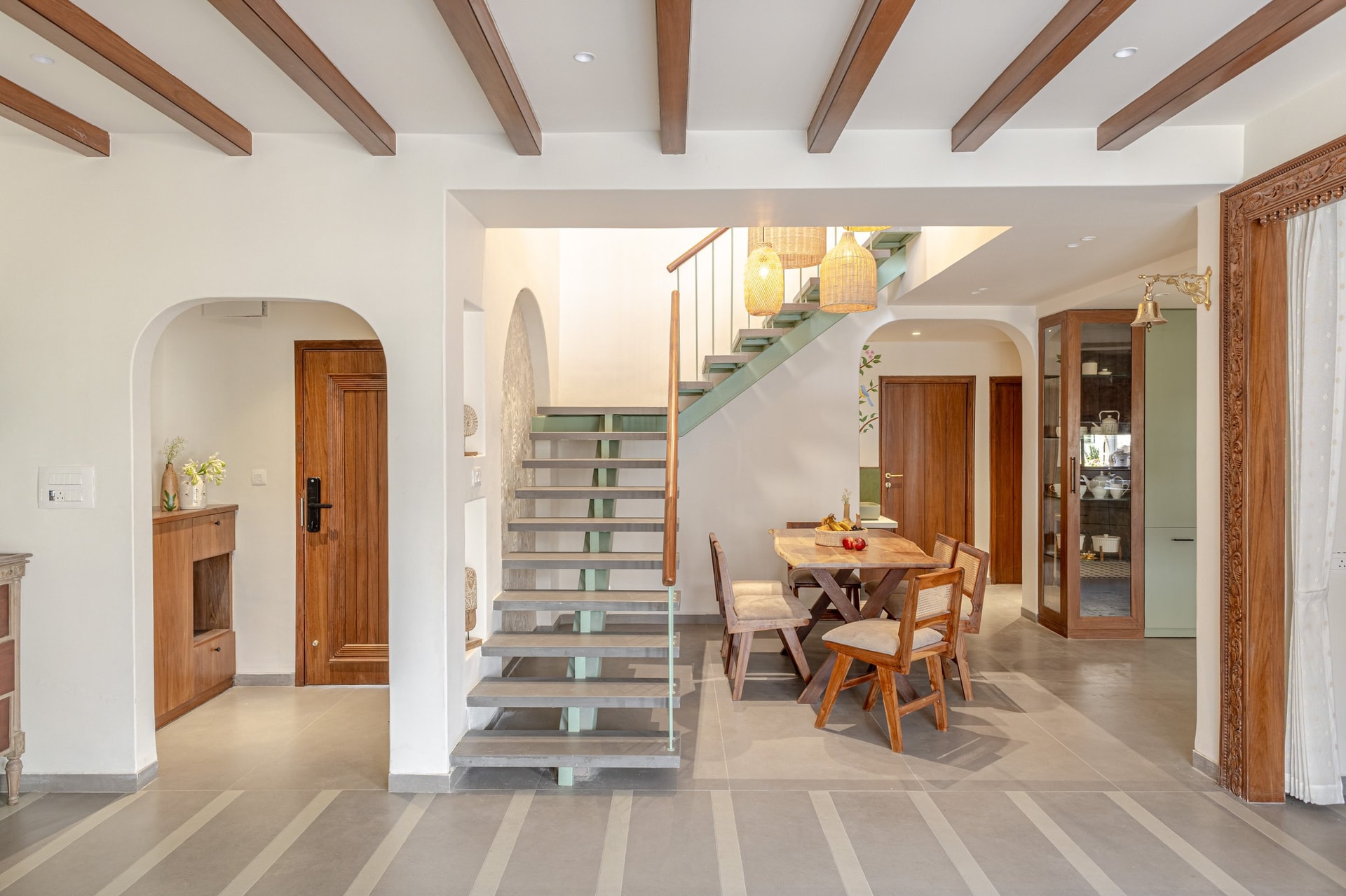 The central staircase volume, organised around a custom sage-green metal structure that reshapes the entire duplex plan