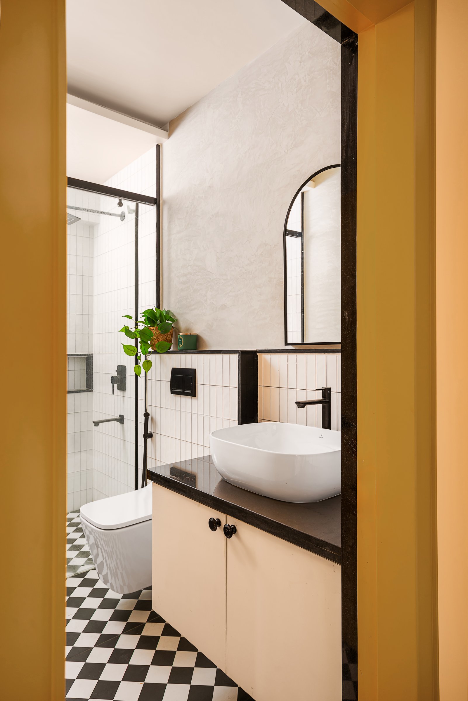 The common bathroom, with its checkerboard floor, subway tiles, and textured plaster above